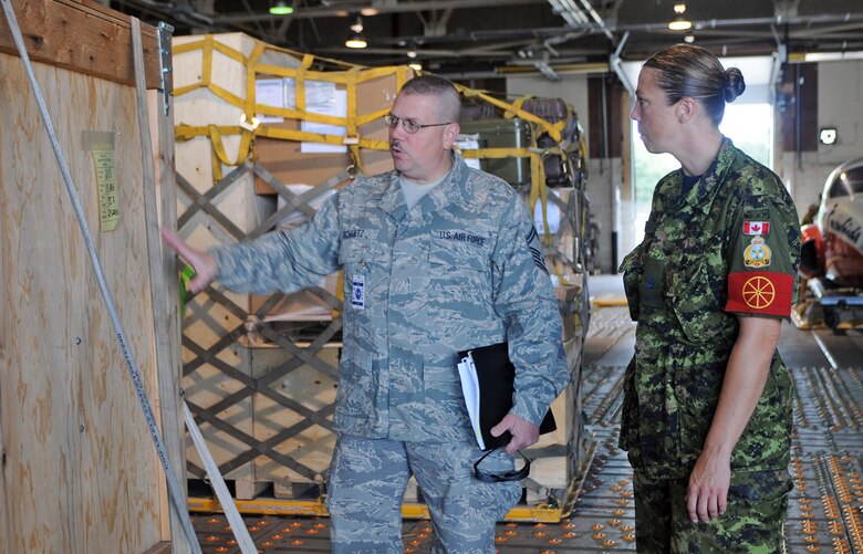 Senior Master Sgt. Dan Schultz discusses aerial port operations Aug. 24 with Canadian Royal Air Force Warrant Officer April Roach of the 2 Air Movements Squadron, a unit of the 8 Wing at Canadian Forces Base Trenton, Ontario.  Ten aircrew members from Air Force Reserve Command's 512th Airlift Wing at Dover Air Force Base, Del., flew to the Canadian base to spend three days with Royal Canadian Air Force members to forge a partnership and identify future training opportunities for flying, aerial port operations, airlift control and maintenance procedures. Sergeant Schultz is the NCO in charge of the 46th APS ramp at Dover AFB.  (U.S. Air Force photo/Capt. Marnee A.C. Losurdo)