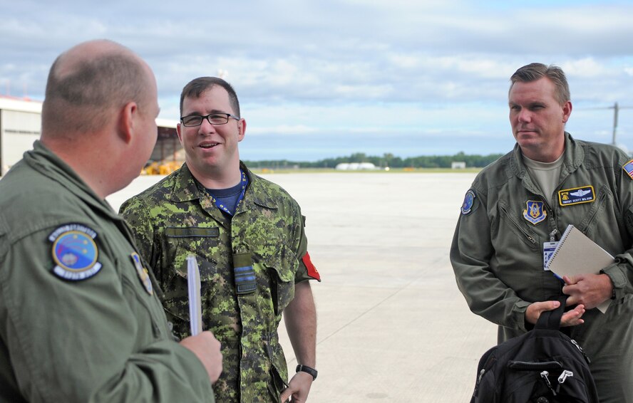 Tech. Sgt. Henry Fortney (left) and Senior Master Sgt. Scott Wilson (right) meet with Canadian air force Maj. Aaron Spott, 2 Air Movements Squadron commanding officer, during a visit to the 8 Wing at Canadian Forces Base Trenton, Ontario.  Ten aircrew members from Air Force Reserve Command's 512th Airlift Wing at Dover Air Force Base, Del., flew to the Canadian base to spend three days with Royal Canadian Air Force members to forge a partnership and identify future training opportunities for flying, aerial port operations, airlift control and maintenance procedures. Sergeant Fortney is a loadmaster with the 512th Airlift Control Flight and Sergeant Wilson is the 512th ALCF superintendent.  (U.S. Air Force photo/Capt. Marnee A.C. Losurdo)