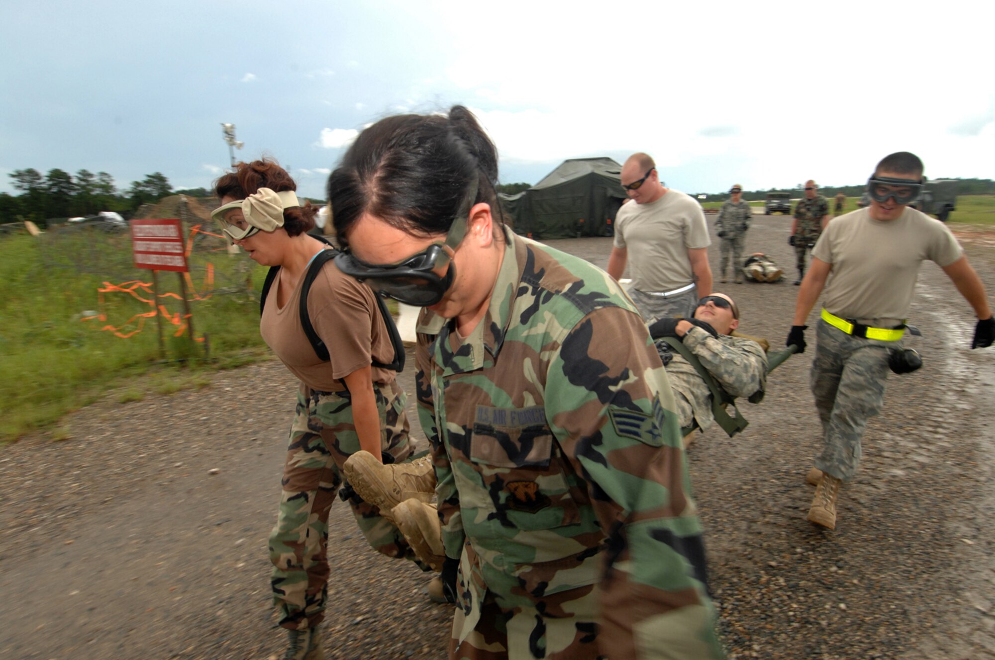 Airmen carry a simulated patient from the Mobile Aeromedical Staging Facility to an awaiting transport during action in the Joint Readiness Training Exercise 09-09, Aug. 20, 2009, at Fort Polk, La. (U.S. Air Force Photo/Tech. Sgt. Nic Raven)