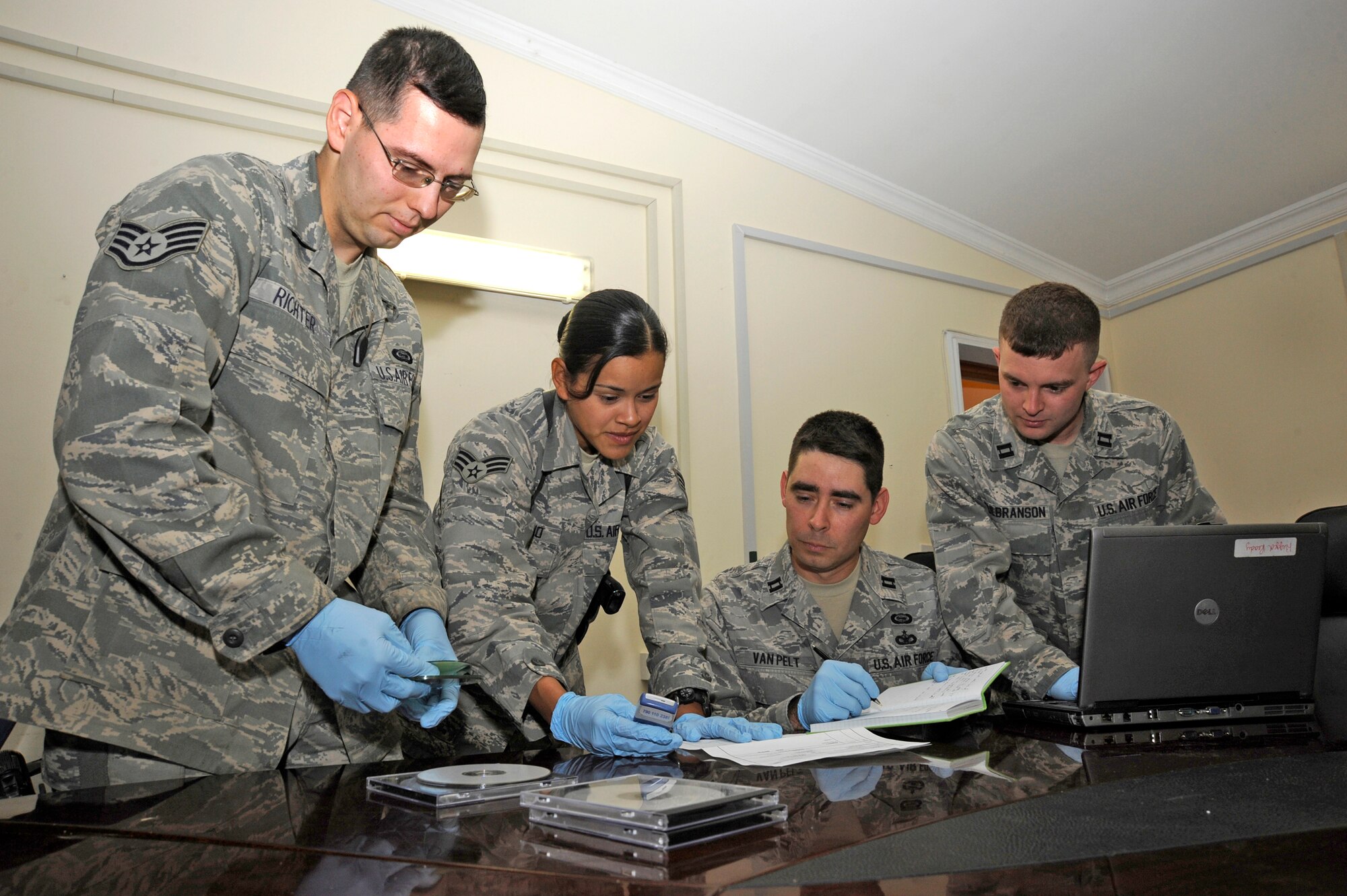 Tactical Document and Media Exploitation Brigade Support team members triage evidence taken from captured enemies here Aug. 21. The DOMEX mission is to exploit information from captured enemy documents, electronic media and cell phones. The team's work contributes to theater and national intelligence efforts in support of targeting and detainee operations, force protection and criminal prosecution. (U.S. Air Force photo/Tech. Sgt. Johnny L. Saldivar)
