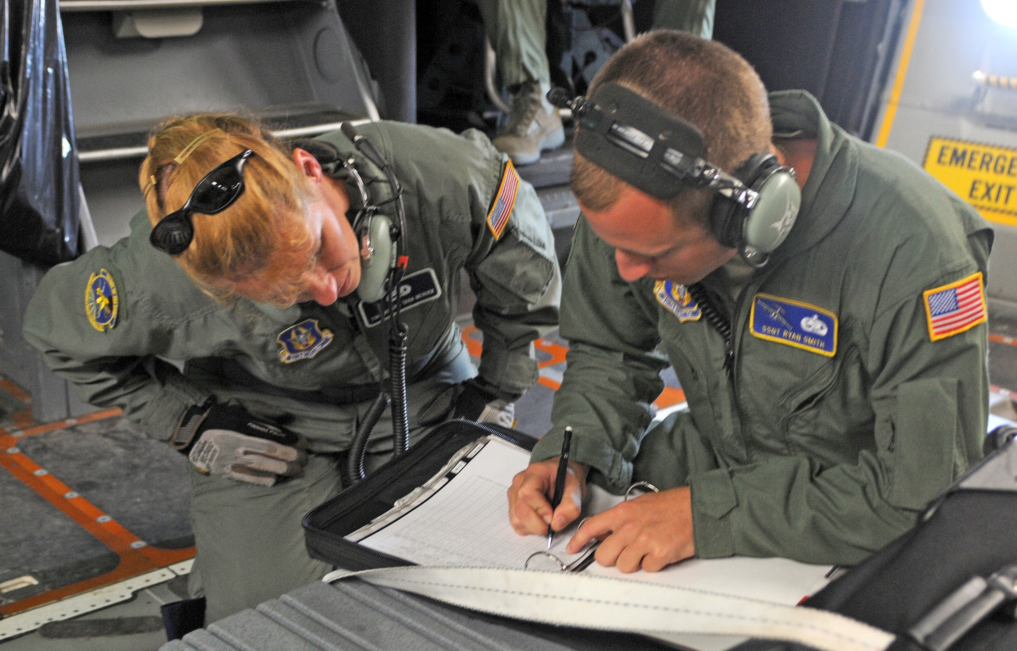 Tech. Sgt. Athena Mercer and Staff Sgt. Ryan Smith complete their maintenance checklists onboard a C-17 Globemaster III prior to take off Aug. 22.  The two maintainers from the Air Force Reserve Command's 512th Airlift Wing at Dover Air Force Base, Del., were part of a crew going to visit Canadian airmen in the 8 Wing at Canadian Forces Base Trenton in Ontario Aug. 22 through 24. The purpose of the visit was to forge a partnership with the Canadian wing and identify future training opportunities for flying, aerial port operations, airlift control and maintenance procedures. (U.S. Air Force photo/Capt. Marnee A.C. Losurdo)