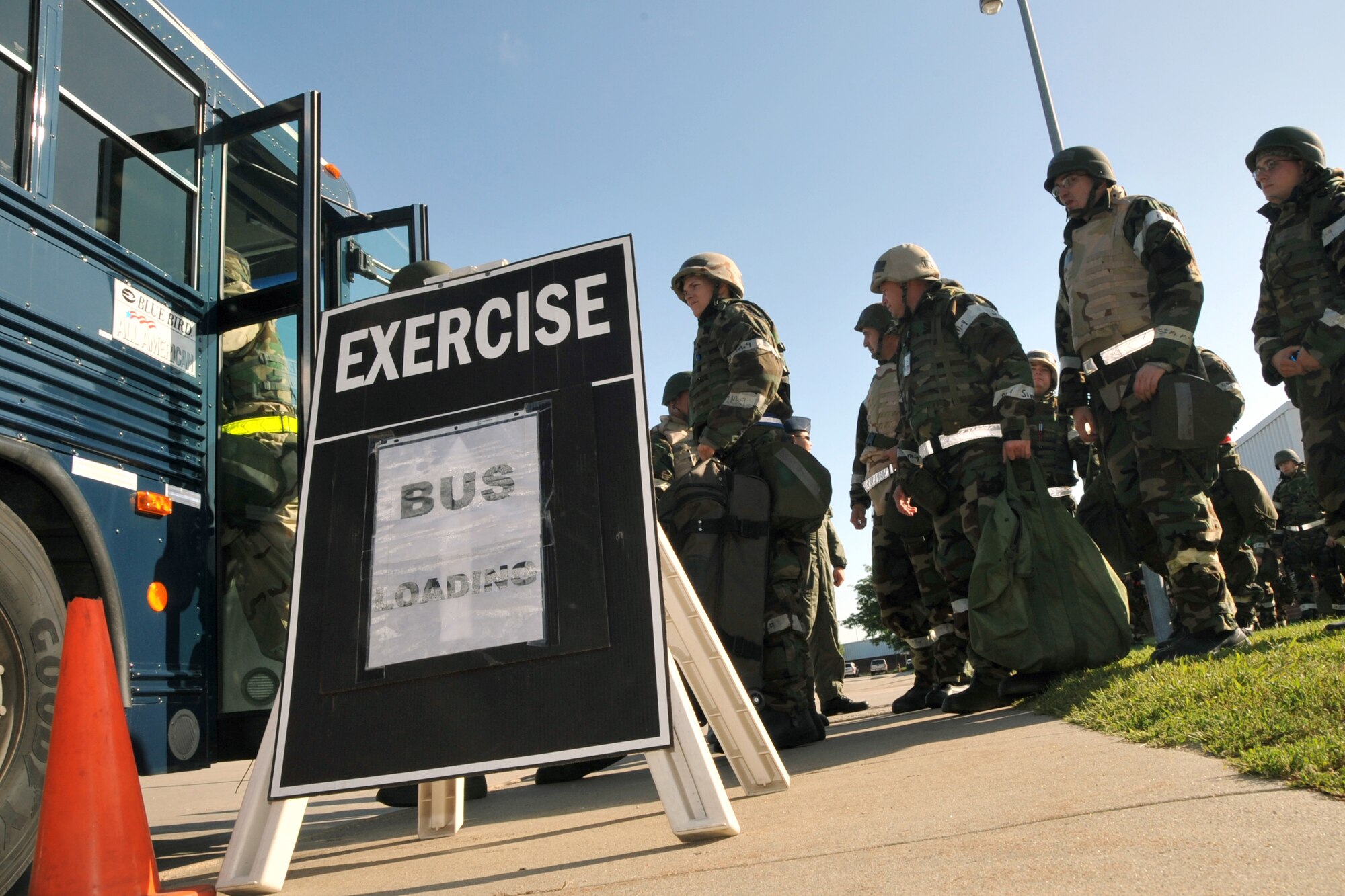 OFFUTT AIR FORCE BASE, Neb. -- Members of the Fightin' Fifty-Fifth participating in an expeditionary training day board a bus outside the Bennie Davis Maintenance Facility here Aug. 20 so they can be transported to the exercise play area. The training day consisted of self aid buddy care, post attack reconnaissance sweeps and the proper donning of chemical gear. U.S. Air Force Photo by Jeff W. Gates.