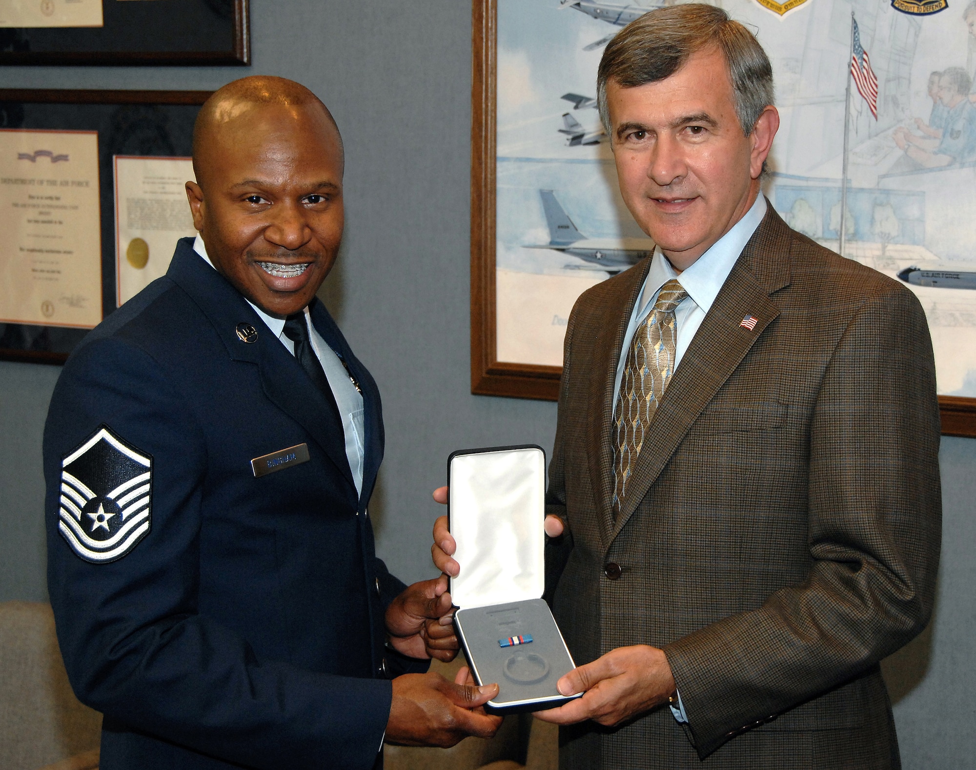 OFFUTT AIR FORCE BASE, Neb. - Mike Johanns, Nebraskan senator,  presents Master Sgt. Tyrone F. Bingham, host aviation resource manager for the 170th Operational Support Squadron here, with a medal for his selection as one of 12 Outstanding Airmen of the Year during the senator's visit to Offutt Aug. 20.
U.S. Air Force photo by D.P. Heard