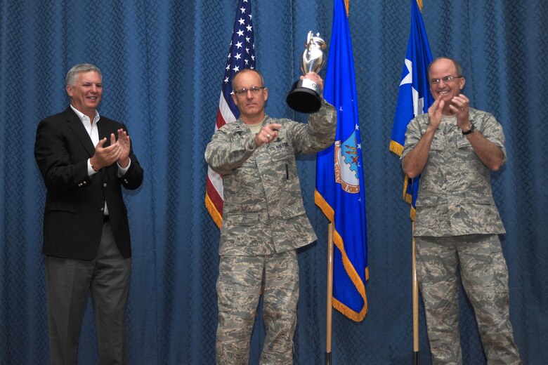 Col. Michael Fortney, 341st Missile Wing commander (center), points to Malmstrom Airmen after receiving the 2008 Omaha Trophy from Gen. Kevin Chilton, U.S. Strategic Command commander (right), and Mr. Gary Gates, USSTRATCOM Consultation Committee representative (left), Aug. 26 at Malmstrom Air Force Base, Mont. The trophy is awarded to a unit who demonstrates the highest standards of performance, and the selection for the award is based on meritorious achievements, safety, community involvement and humanitarian actions. (U.S. Air Force photo/Beau Wade)