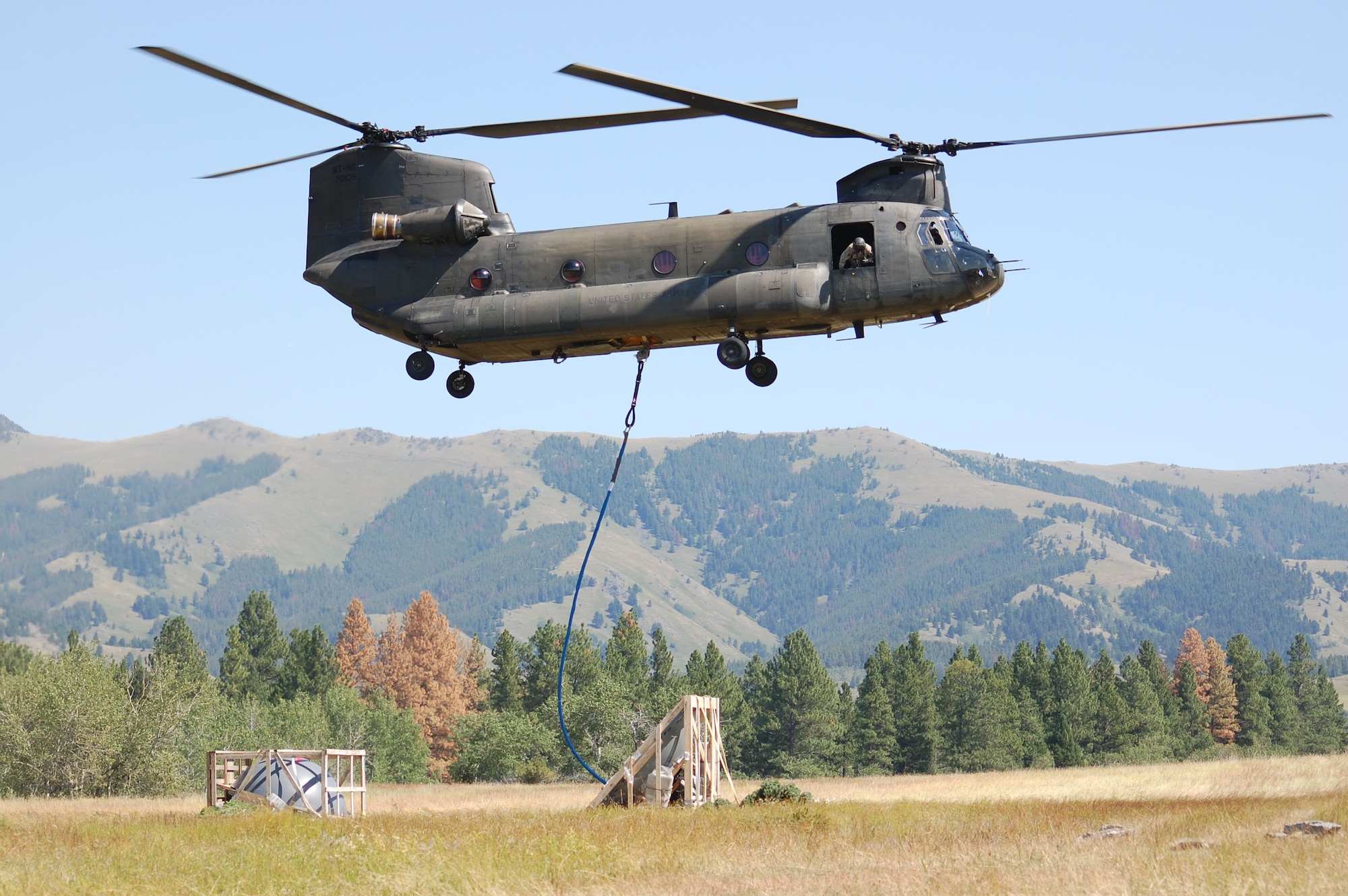 A CH-47 Chinook helicopter from the Montana Army National Guard carries microwave dishes up to Highwood Baldy Mountain roughly 40 miles northeast of Great Falls Aug. 21 in support of the Wide Area Coverage Project supported by Air Force Space Command. The project brings Air Force and Montana communication capabilities into the 21st Century through digital communication. Four microwave dishes will be installed on a 100-foot tower that was brought up in 20-foot sections.  The MANG completed 50 lifts in a two week time frame. Today was the culmination of the last airlift. The new antenna will also support Choteau, Cascade and Judith Basin counties; Montana Highway Patrol; Montana Department of Transportation; local law enforcement agencies; and first-responders. (U.S. Air Force photo/Staff Sgt. Eydie Sakura)
