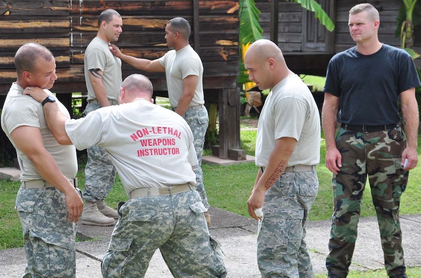 SOTO CANO AIR BASE, Honduras — Army Sgt. 1st Class Robert Robinson, U.S. Army South deputy of state provost martial, and the course instructor, demonstrates a brachial plexus clavicle notch technique on Army Staff Sgt. Pedro Navarro Aug. 20 at the JSF compound while Air Force staff sergeants Gary Stacey and Scottie Trimble observe his technique. Sergeant Robinson came to Soto Cano to provide nonlethal training to the Joint Security Forces members in order to get all the deployed members qualified. Some of the things they learned were riot control, advanced techniques with the baton and pressure point control (U.S. Air Force photo/Staff. Sgt. Chad Thompson).