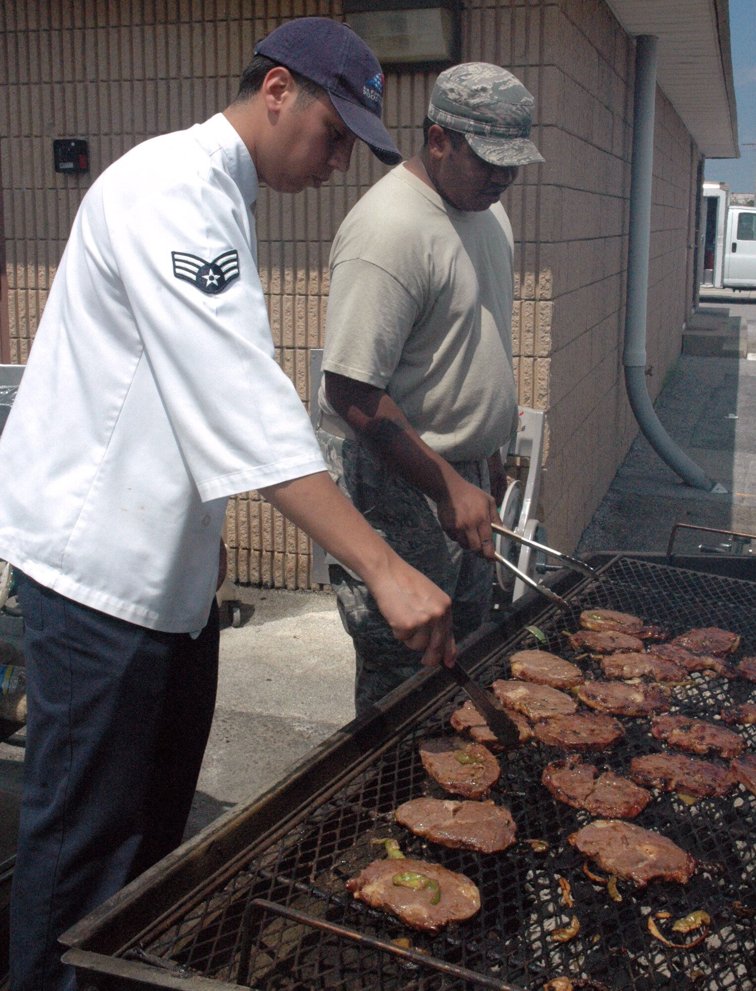 Tyndall AFB, Fla. - Staff Sgt. Dennis Beck, 325th Force Support Squadron and Senior Airman Elias Peredo prepare steaks for the Flight Line Appreciation Meal on Aug. 26 from 10:30 a.m. to 1:30 p.m. Servicemembers who work on the flight line received a free lunch that included steak and shrimp with several tasty side dishes.   