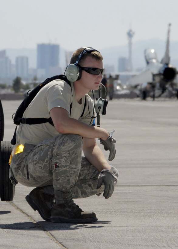 With downtown Las Vegas in the background, Airman 1st Class Kevin O'Brien keeps an eye on operations on the flightline at Nellis Air Force Base, Nev., Aug. 25 while waiting for aircraft from his unit to take off for a Red Flag training mission.  Red Flag offers pilots and ground crews training in actual wartime scenarios to increase their combat skills.  Airman O'brien is with the Massachusetts Air National Guard's 104th Fighter Wing at Barnes Air National Guard Base in Westfield, Mass.  (U.S. Air Force photo/Senior Master Sgt. Robert J. Sabonis)