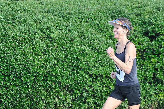 Carol Riley darts to the finish of the 5,000-meter running portion of a triathlon held here Aug. 22. Riley won the first place award for the 60 to 99 female age group. Riley is retired from the Navy. (U.S. Air Force photo/James M. Bowman)