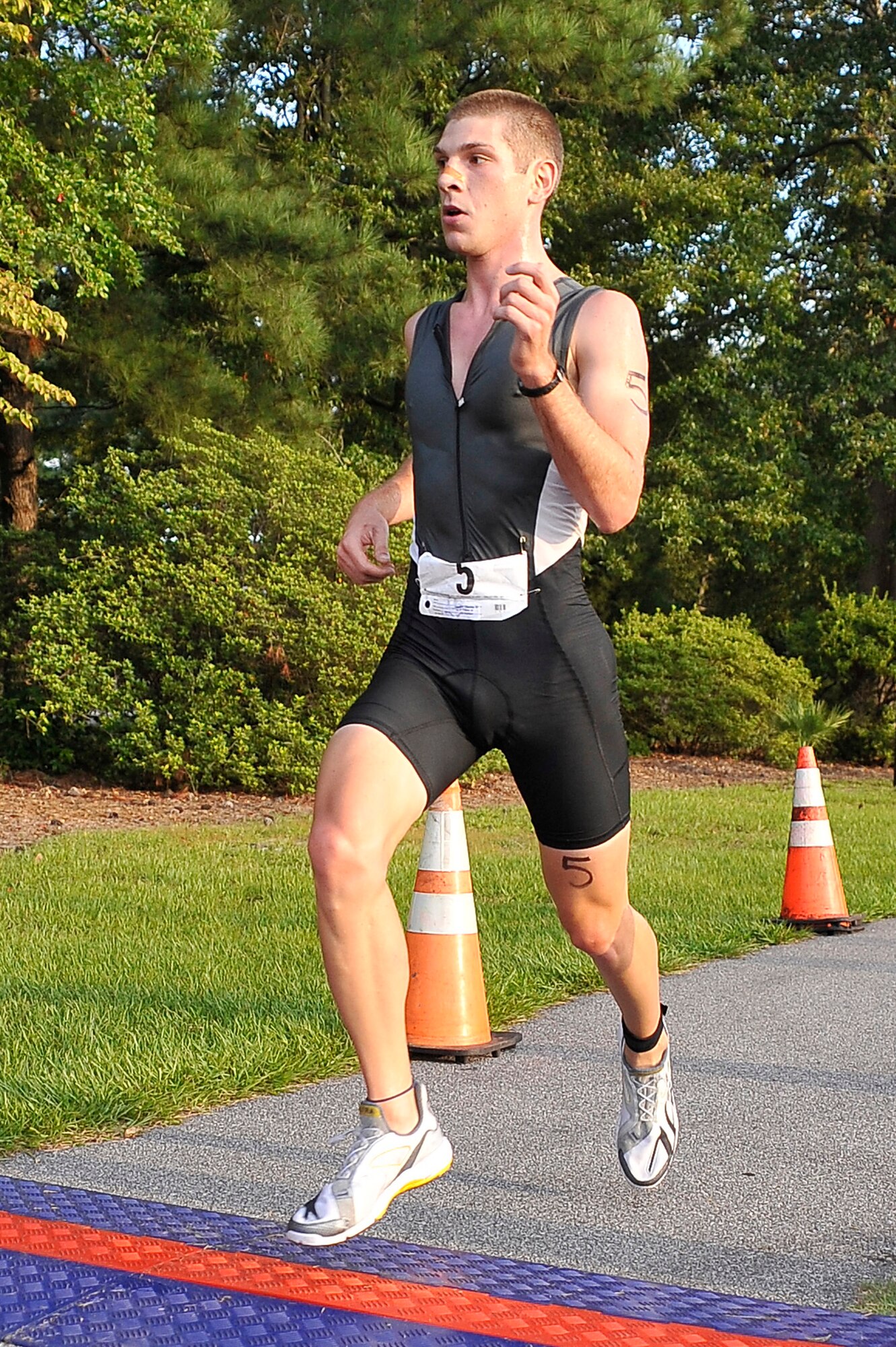 Charles Kreuzberger crosses the finish line, completing the 5,000-meter running portion of a triathlon held here Aug. 22. Awards were given for the top male and female finishers in nine categories based on age. Kreuzberger is a member of the Navy. (U.S. Air Force photo/James M. Bowman)




