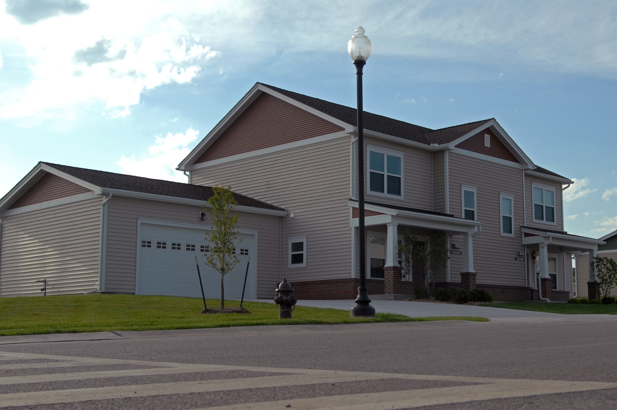 WHITEMAN AIR FORCE BASE, Mo. - This home on Vosler Avenue was the setting of a ribbon cutting ceremony for new military housing here Aug. 21. Airman 1st Class Joseph Robin, 509th Security Forces Squadron, his wife, Molly, and their 11-month old daughter, Charli, were the first to receive one of the new homes built by Walsh Construction. (U.S. Air Force photo/Senior Airman Kenny Holston)
