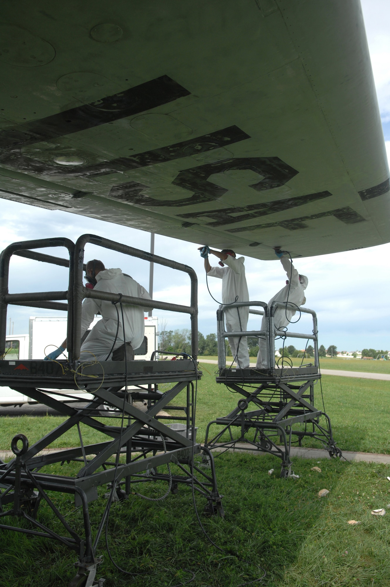 WHITEMAN AIR FORCE BASE, Mo. - Members from the 509th Maintenance and Munitions squadrons restore the protective coating on a KC-97 static display here Aug. 20.  The restoration, which is required every five years, is scheduled to take a month.  During this time Airman will sand, repaint and perform any required sheet metal repair to the KC-97. (U.S. Air Force photo/Senior Airman Jessica Snow)