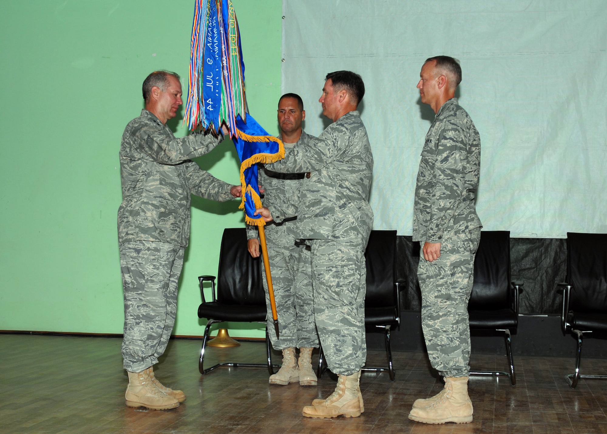 Maj. Gen, Ronald R. Ladnier (left), commander of 17th Air Force (Air Forces Africa), accepts the 449th Air Expeditionary Group flag from outgoing commander Col. John Brunhaver (center) during a change of command ceremony at Camp Lemonier, Djibouti Aug. 26. Waiting to accept the flag is incoming commander Col. Jon Ullmann (right) as 449th Command Chief Master Sergeant Bradlee Farrin assists. Colonel Ullmann is normally the Combat Operations Division Director for 17 AF's 617th Air Operations Center, located at Ramstein Air Base, Germany. Col. Brunhaver returns to Air Mobility Command at Scott AFB, Ill., where he is the Division Chief for the Expeditionary Mobility Operations Division. (USAF photo by Master Sgt. Jim Fisher) 