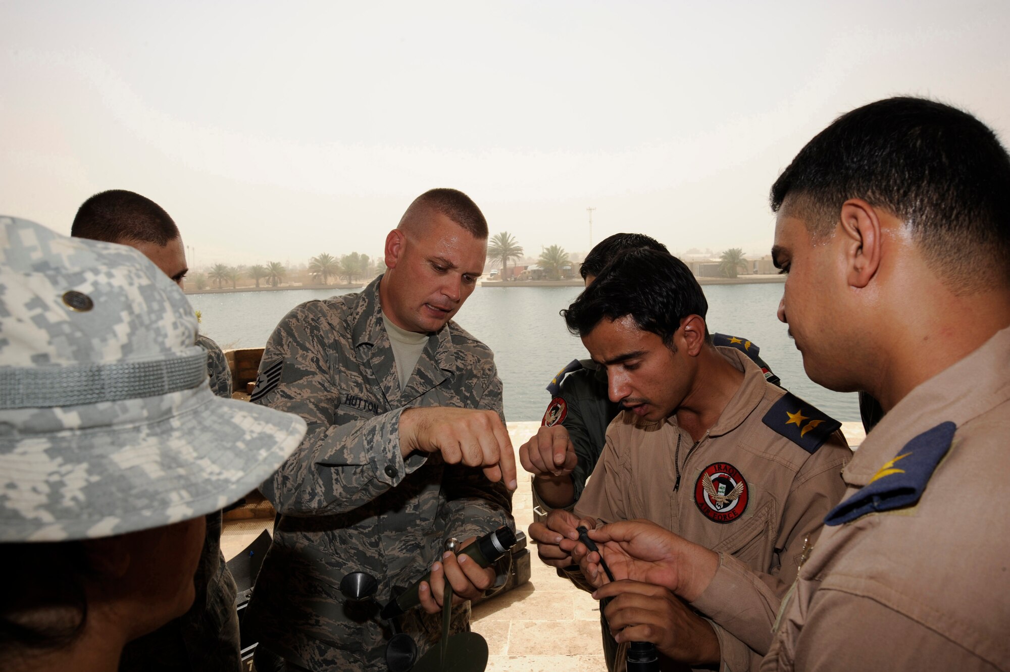 CAMP VICTORY, Iraq -- Air Force Tech. Sgt. Terry Hutton, weather system support cadre team lead assigned to the Combined Air and Space Operations Center in Southwest Asia, teaches Iraqi air force weather lieutenants how to properly connect a wind sensor cable to a wind sensor mast on a TMQ-53 tactical meteorological observation system during on-the-job training here Aug. 16, 2009. This training enabled the Iraqi officers to set-up, maintain and break down the equipment used to obtain pressure, wind speed and direction, temperature, dew point, relative humidity, precipitation, surface visibility, cloud height and lightning detection. This system will enable Iraqi weather airmen to provide current weather data to their leadership in support of their missions throughout Iraq. Sergeant Hutton is deployed from Hurlburt Field, Fla., and is a native of Enid, Okla.  (U.S. Air Force photo/Tech. Sgt. Johnny L. Saldivar) 