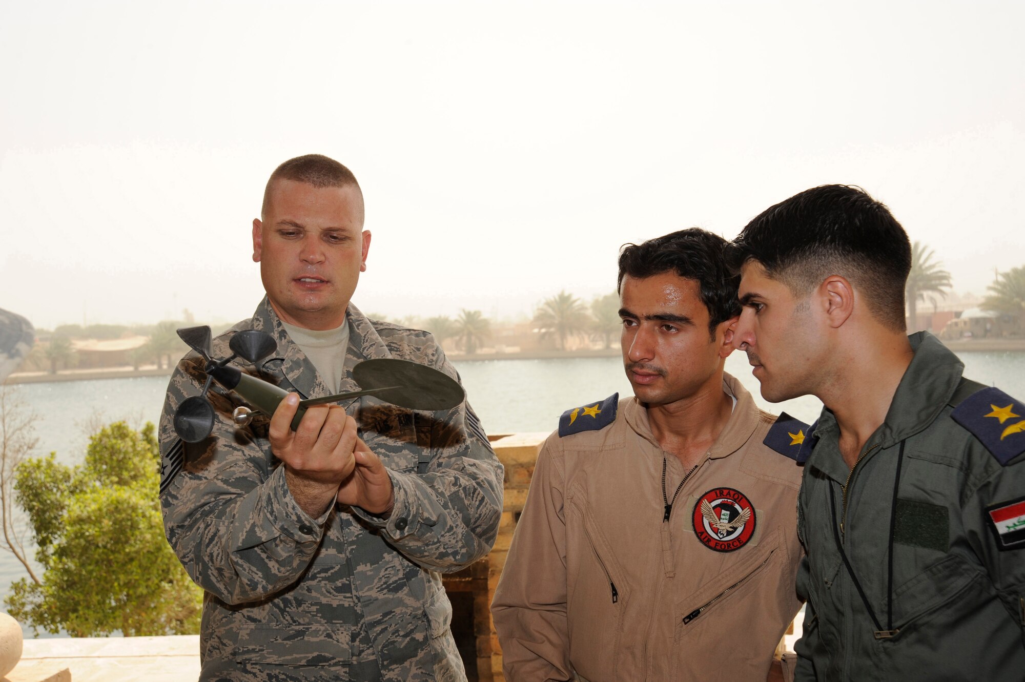 CAMP VICTORY, Iraq -- Air Force Tech. Sgt. Terry Hutton, weather system support cadre team lead assigned to the Combined Air and Space Operations Center in Southwest Asia, teaches Iraqi officers preventative maintenance actions for a wind sensor here Aug. 16, 2009. The procedure ensures the device, which connects to a TMQ-53 tactical meteorological observation system, is free of any debris that could prevent it from rotating freely. This system will enable the Iraqis to provide current weather data to their leadership in support of their missions throughout Iraq. Sergeant Hutton is deployed from Hurlburt Field, Fla., and is a native of Enid, Okla.  (U.S. Air Force photo/Tech. Sgt. Johnny L. Saldivar) 