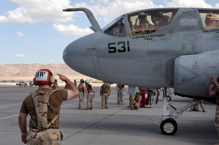 NELLIS AIR FORCE BASE, Nev.-- U.S. Navy Airman Jimmy Main, an EA-6B Prowler flight captain from Electronic Attack Squadron 133, Naval Air Station Whidbey Island, Wash., salutes Lt. Cmdr. Kelly Richards during a Red Flag 09-5 sortie launch Aug. 24. Red Flag is a realistic air combat training exercise conducted over the 15,000-square-mile Nevada Test and Training Range north of Las Vegas. The two-week exercise is administered through the 414th Combat Training Squadron at Nellis Air Force Base and is just one in a series of advanced training programs offered by the U.S. Air Force Warfare Center. U.S. Air Force, Navy and Marines Corps units from Nevada, Massachusetts, Utah, Louisiana, California, Washington, Oklahoma, Florida and Kansas are participating in Red Flag 09-5 along with allied forces from Italy and the United Arab Emirates. The exercise ends Sept. 4. (U.S. Air Force photo by Airman 1st Class Brett Clashman/Released)