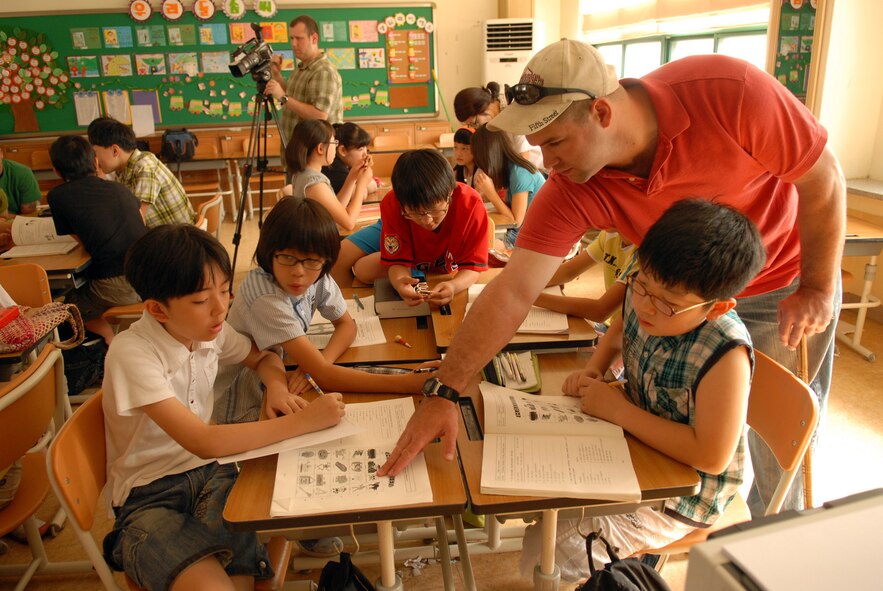 GUNSAN CITY, Republic of Korea -- Staff Sgt. John Devine, 8th Security Forces Squadron, points at a picture while Korean elementary students repeat the word in English Aug. 14 at a local Gunsan City elementary school. Sergeant Devine and more than 20 other Wolf Pack members volunteered at the annual Summer English Camp, near Kunsan Air Base, Republic of Korea. The camp's purpose is for American volunteers to assist Korean teachers with teaching English. The camp occur twice a year. (U.S. Air Force photo/Staff Sgt. Patrice Clarke)
