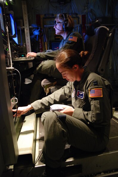 HICKAM AIR FORCE BASE -- Capts. Ellen Bundy and Tina Smith, 53rd Weather Reconnaissance Squadron meteorologists, study data obtained during a 10-hour mission through tropical storm Felicia Aug. 7. The unit, also known as the Hurricane Hunters, operate the WC-130J aircraft for weather reconnaissance into some of the most violent storms on Earth -- tropical cyclones. Hurricane Felicia reached peak strength as a Category 4 storm with sustained winds of more than 145 mph. The 53rd WRS is a one-of-a-kind U.S. Air Force Reserve unit and the only Department of Defense organization still flying into tropical storms and hurricanes since 1944. Their fleet of 10 Lockheed-Martin WC-130J aircraft and crews are part of the 403rd Wing, based at Keesler Air Force Base, Biloxi, Miss. (U.S. Air Force photo/Staff Sgt. Mike Meares)