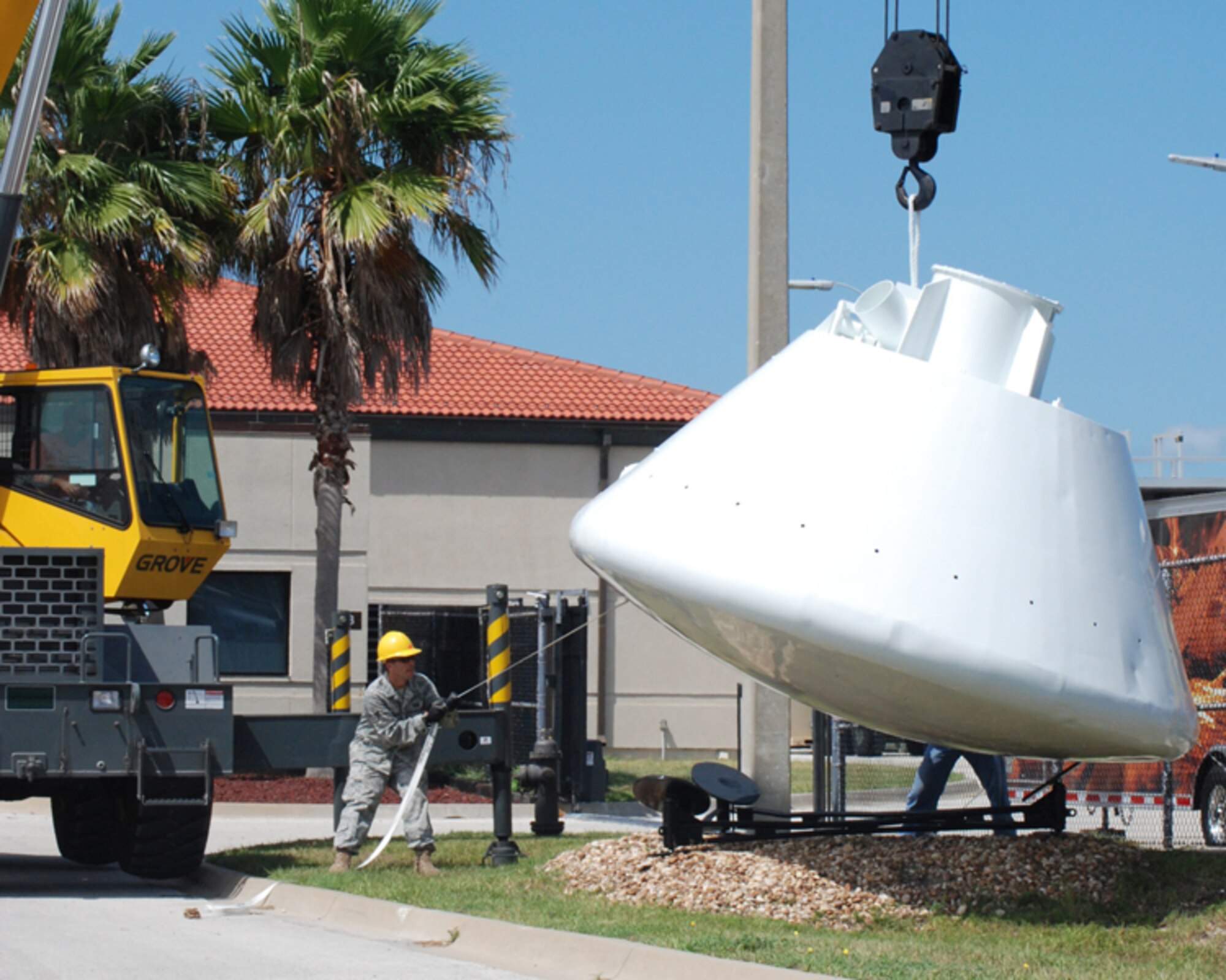 PATRICK AIR FORCE BASE, Fla. - Staff Sgt. Billie Tyson lowers a 9,000-pound space capsule that arrived back at the Air Force Reserve Command's 920th Rescue Wing here from refurbishment at Excell Coatings Inc. at Port Canaveral. The capsule was used in England by U.S. Air Force rescue personnel in the 67th Aerospace Rescue and Recovery Squadron at Royal Air Force Woodbridge to train in recovery operations for both the Apollo and Skylab programs. The capsule has been on loan from the Smithsonian Institute's National Air and Space museum to the 920th Rescue Wing since 1992.  Since the 920th RQW plays a major role in space support, it's a fiting display for the entrance to the pararescue squadron here.