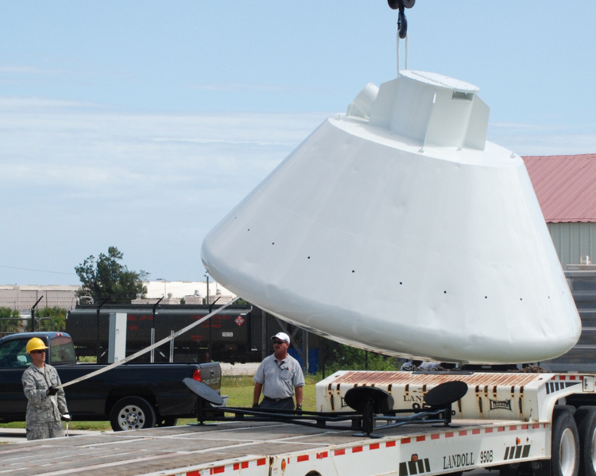 PATRICK AIR FORCE BASE, Fla. - Staff Sgt. Billie Tyson works with Tim Harris to move a 9,000-pound space capsule that arrived back at the Air Force Reserve Command's 920th Rescue Wing here from refurbishment at Excell Coatings Inc. at Port Canaveral. The capsule was used in England by U.S. Air Force Rescue personnel in the 67th Aerospace Rescue and Recovery Squadron at Royal Air Force Woodbridge to train in recovery operations for both the Apollo and Skylab programs. The capsule has been on loan from the Smithsonian Institute's National Air and Space museum to the 920th Rescue Wing since 1992. Since the 920th RQW plays a major role in space shuttle support, it's a fitting display for the entrance of the pararescue squadron here. (U.S. Air Force Photo/Maj. Tricia Hill)