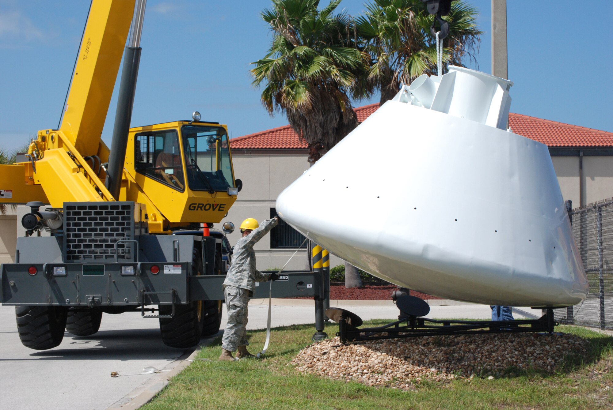 PATRICK AIR FORCE BASE, Fla. - Staff Sgt. Billie Tyson lowers a 9,000-pound space capsule that arrived back at the Air Force Reserve Command's 920th Rescue Wing here from refurbishment at Excell Coatings Inc. at Port Canaveral. The capsule was used in England by U.S. Air Force Rescue personnel in the 67th Aerospace Rescue and Recovery Squadron at RAF Woodbridge to train in recovery operations for both the Apollo and Skylab programs. The capsule has been on loan from the Smithsonian Institute's National Air and Space museum to the 920th Rescue Wing since 1992.  Since the 920th RQW plays a major role in space support, now and throughout history, it's a fitting display at the entrance to the pararescue squadron. (U.S. Air Force Photo/Maj. Tricia Hill)