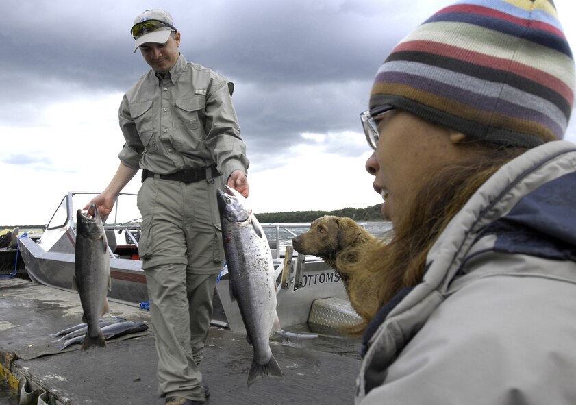 KING SALMON, Alaska -- David Santos, assigned to Fort Richardson's NCO academy, drops fish into the cooler his daughter, Jasmine, is holding open. The Santos' participated in the first Bristol Bay American Heroes Fishing Derby Aug. 6-10 near Elmendorf Air Force Base, Alaska. The derby allowed 11 Soldiers to take one of their children on a four-day fishing trip to King Salmon. (U.S. Air Force photo/Airman 1st Class Christopher Gross)