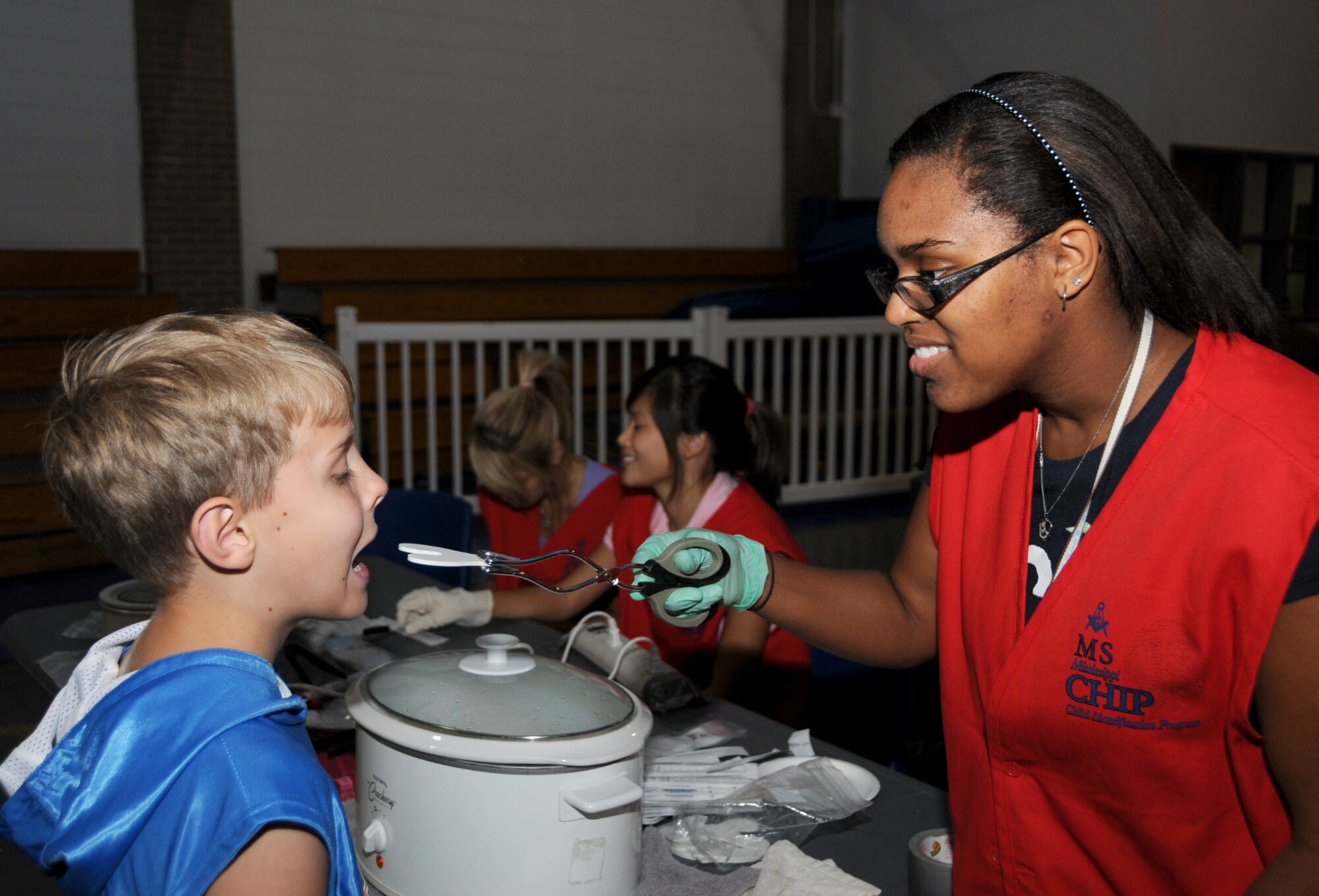 Nine-year-old Garrett Matthews has a tooth print dental impression made by Dionna Russell, another St. Martin High School volunteer.  Garrett’s parents are Master Sgt. Martin and Carolyn Matthews, 81st Logistics Readiness Squadron.  His dad is deployed to Afghanistan.  Parents or guardians also received a laminated identification card and a computer disk with color photos, digital fingerprints, identifying characteristics and family contact information.  (U.S. Air Force photo by Kemberly Groue)