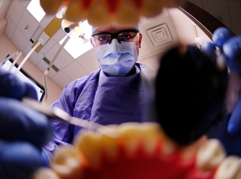 EIELSON AIR FORCE BASE, Alaska -- Staff Sgt. Joel Peace performs a dental exam on a patient at the dental clinic Aug. 19 here. Dental exams determine if there are any problems with teeth as well as provide feedback about the patients' dental hygiene. Sergeant Peace is a dental technician assigned to the 354th Medical Group. (U.S. Air Force photo/Airman 1st Class Laura Goodgame)