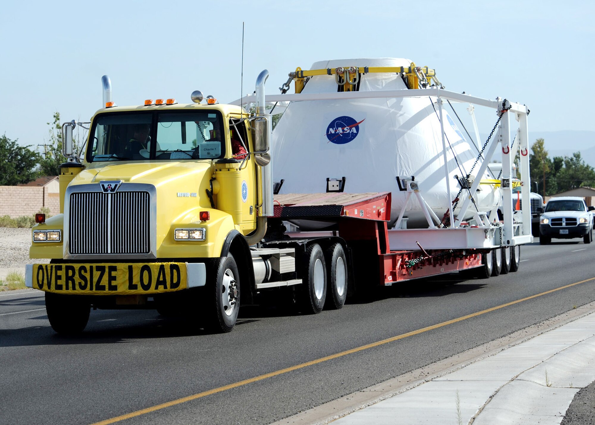 NASA's next generation of manned spacecraft leaves Holloman Air Force Base, N.M. Aug. 21 enroute to White Sands Missile Range, N.M. The module was escorted on base by 49th Security Forces Squadron Airmen and off base by officers from the New Mexico State Police and the New Mexico Department of Public Safety Motor Transportation Division along with deputies from the Otero County Sheriff's Department. (U.S. Air Force photo/Senior Airman Michael Means)
