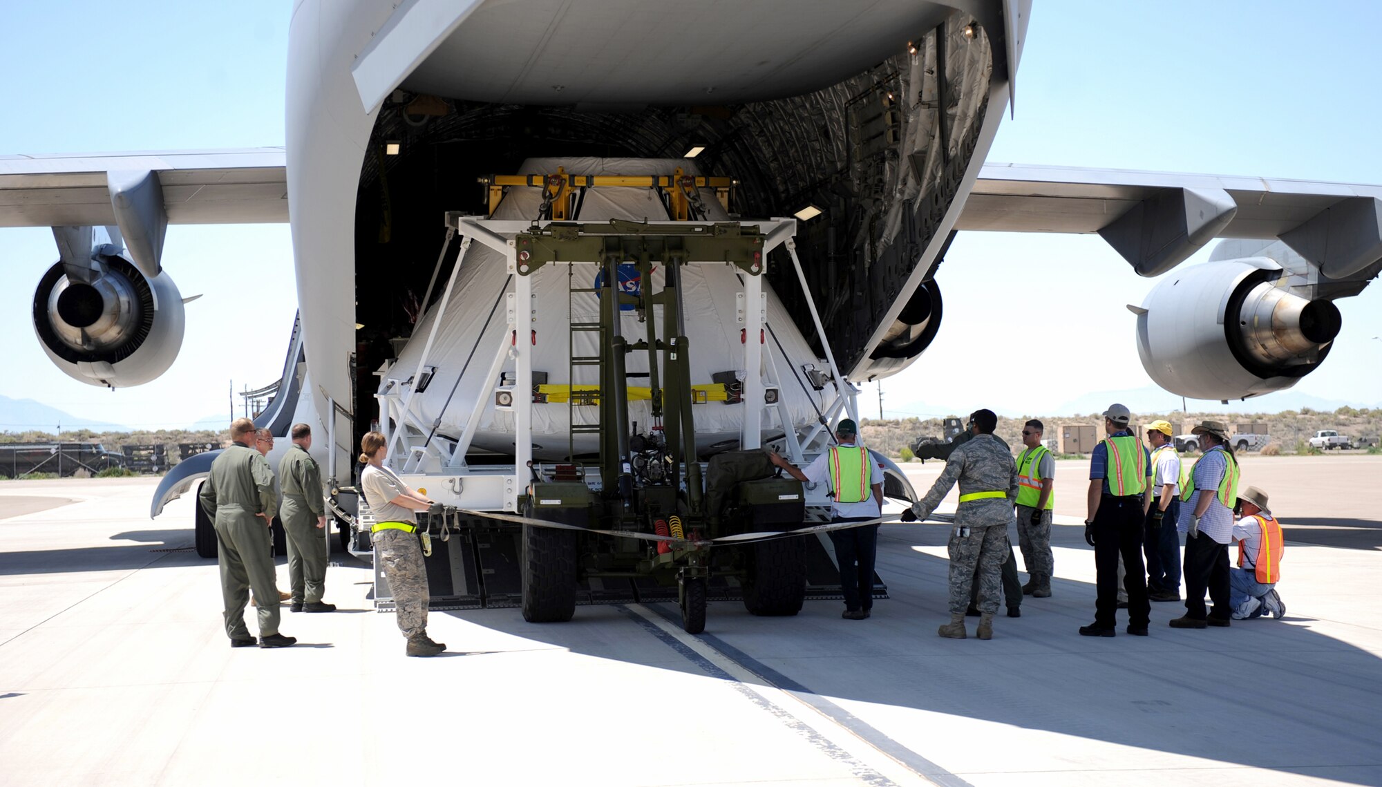 Airmen from the 49th Logistics Readiness Squadron help unload NASA's Pad Abort One Crew Module from a Mississippi Air National Guard C-17 Globemaster III Aug. 19 at Holloman Air Force Base, N.M. The module arrived here from Dryden Flight Research Center, Edwards, Calif. Billed as the shuttle replacement program for NASA, the Orion Program is designed to take the next generation of astronauts to space. (U.S. Air Force photo/Senior Airman Michael Means) 