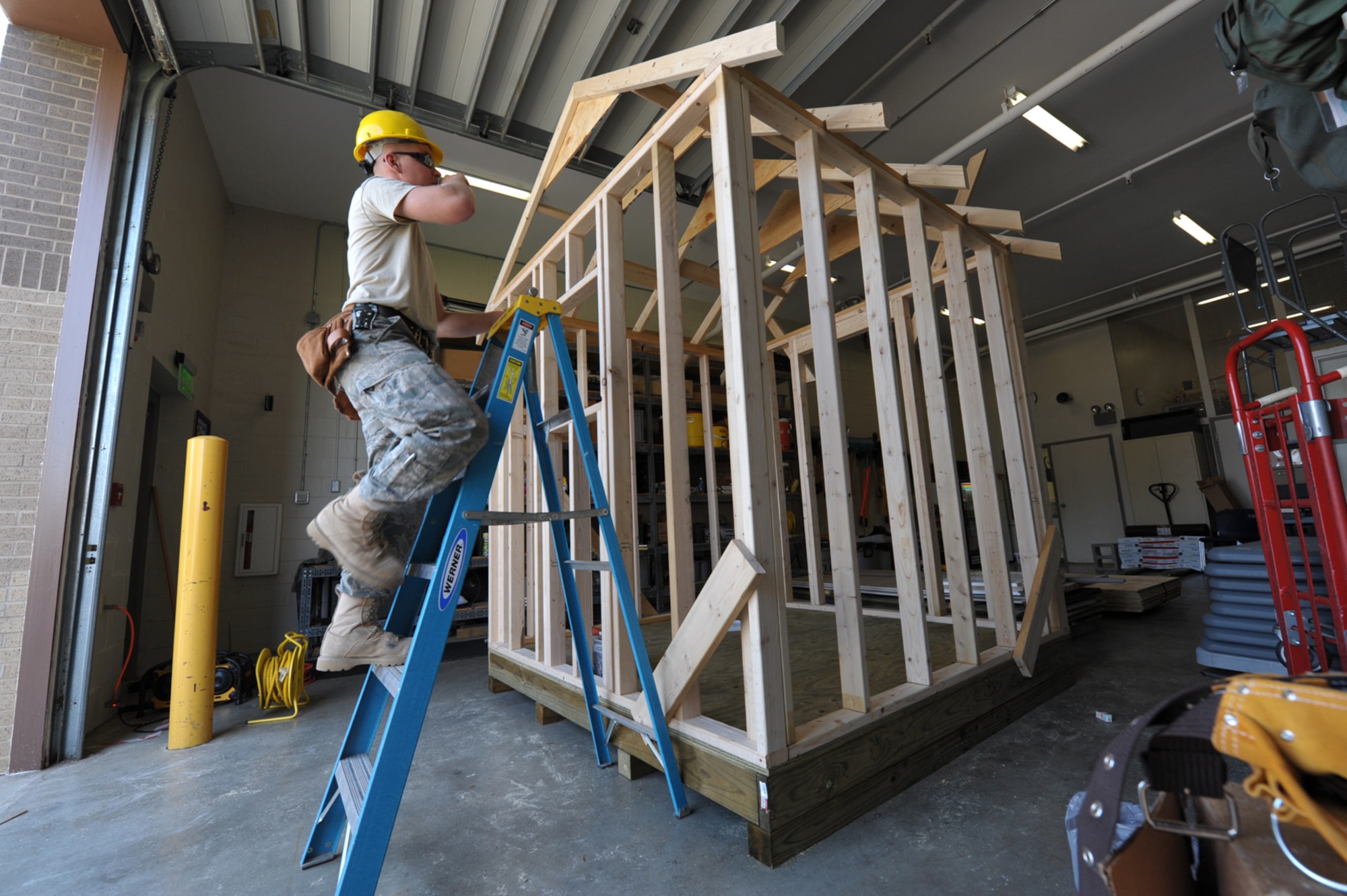 Airman 1st Class Cameron Keating climbs toward the roof of a building his structures team from the 931st Civil Engineer Squadron started to construct during an August training assembly. (U.S. Air Force photo/Tech. Sgt. Jason Schaap)