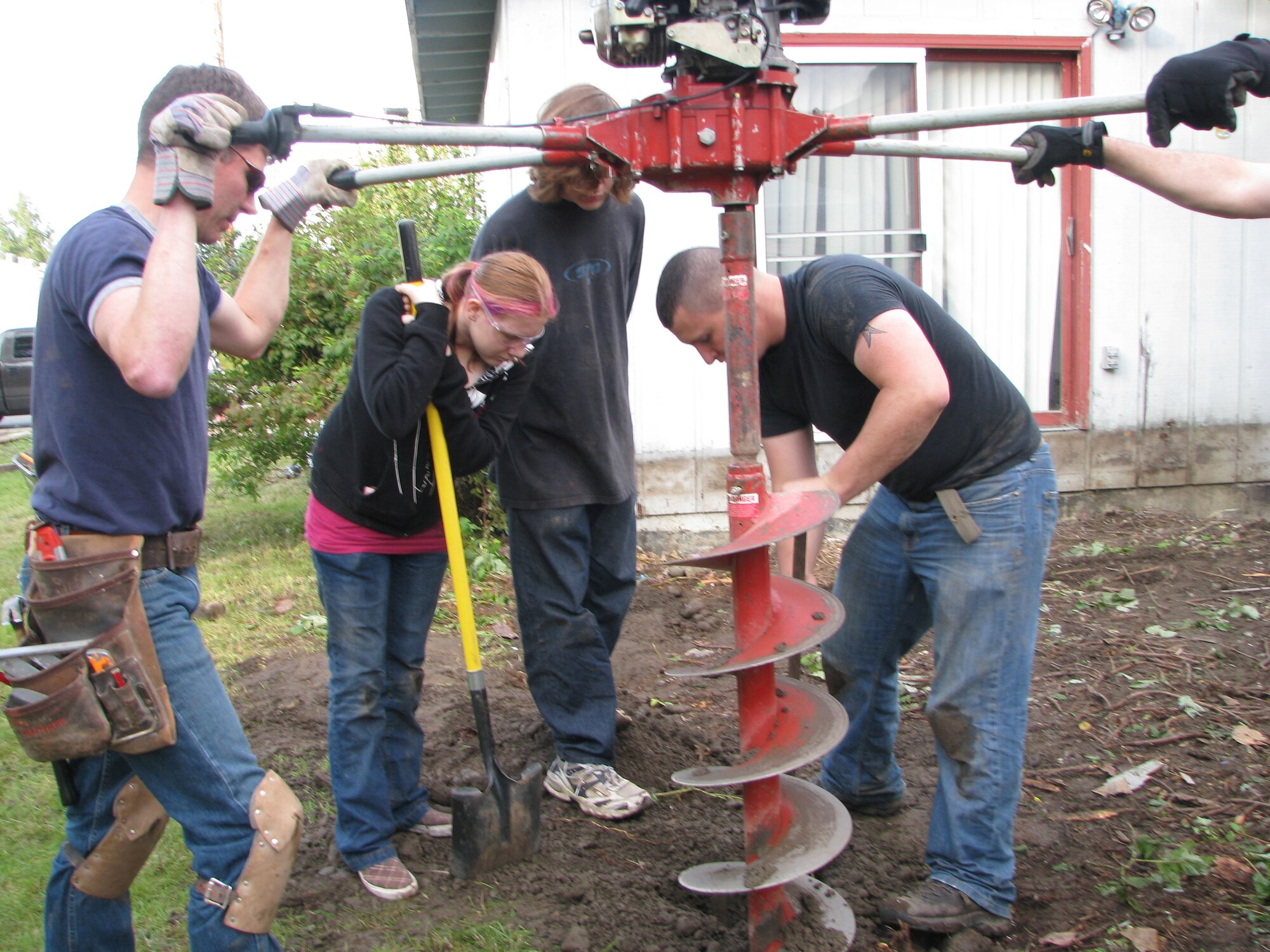 ELMENDORF AIR FORCE BASE, Alaska -- Members of a volunteer group drill new footings that will hold up the new porch to Tech. Sgt. Mary Bramer house. Bramer is the widow of Tech. Sgt. Mark Bramer who died in the Yukla 27 crash. (courtesy photo)