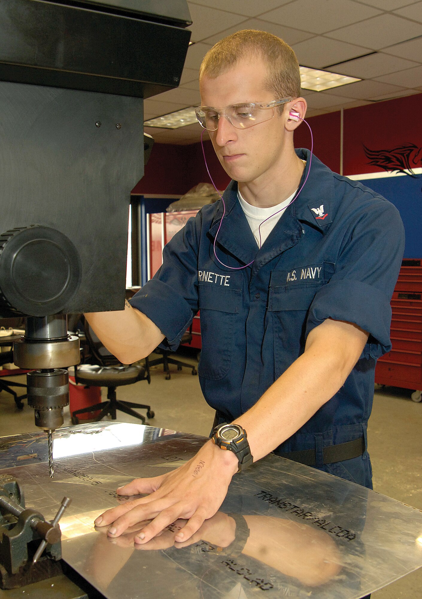 Petty Officer 3rd Class John Barnette pre-drills holes in sheet metal.  Maintainers manufacture doublers to reinforce areas as needed. (Air Force photo by Margo Wright)