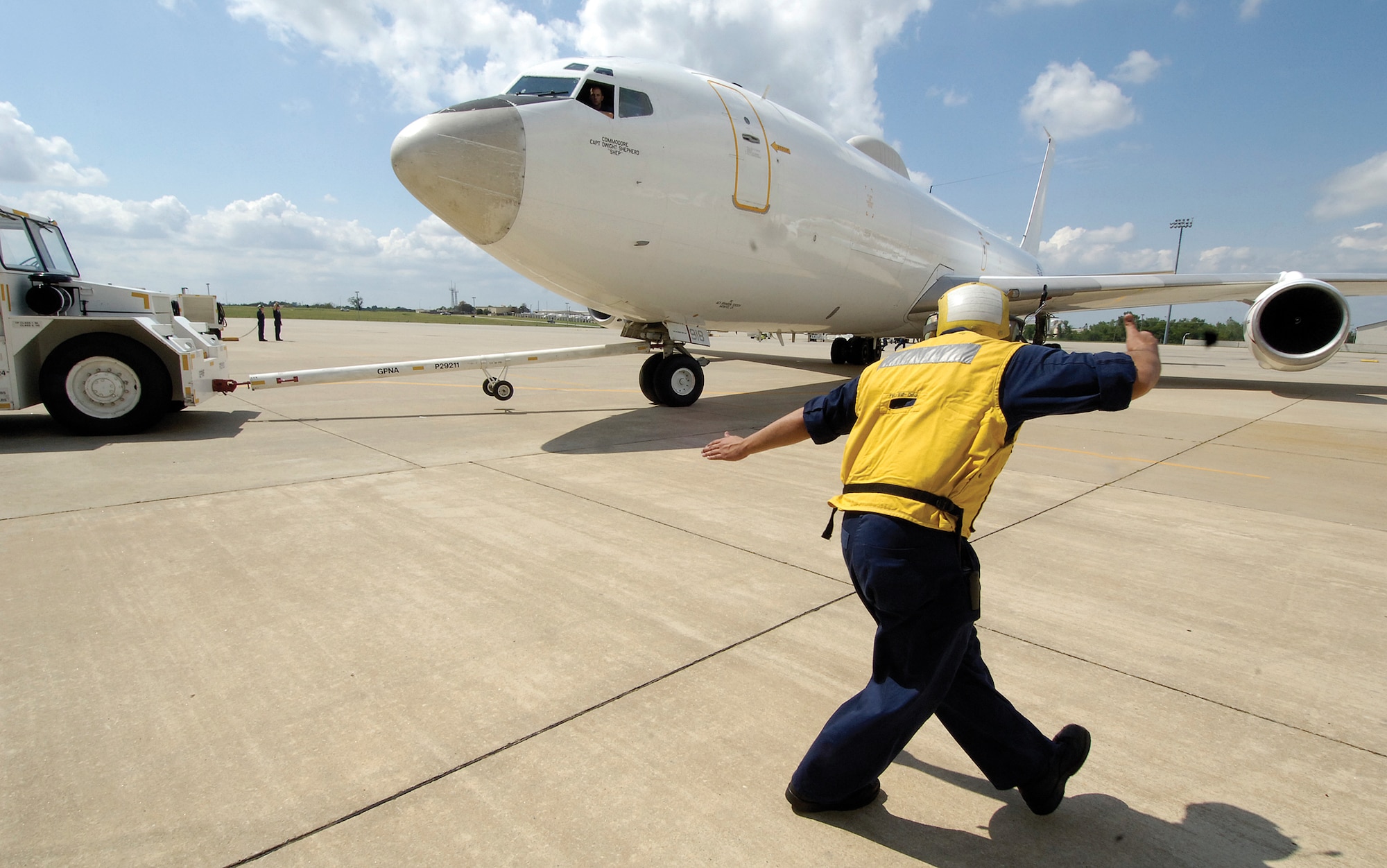 Moving a Navy E-6 out of a VQ-4 maintenance hangar and onto the ramp is a careful process directed by Airman Daniel Flores. (Air Force photo by Margo Wright)