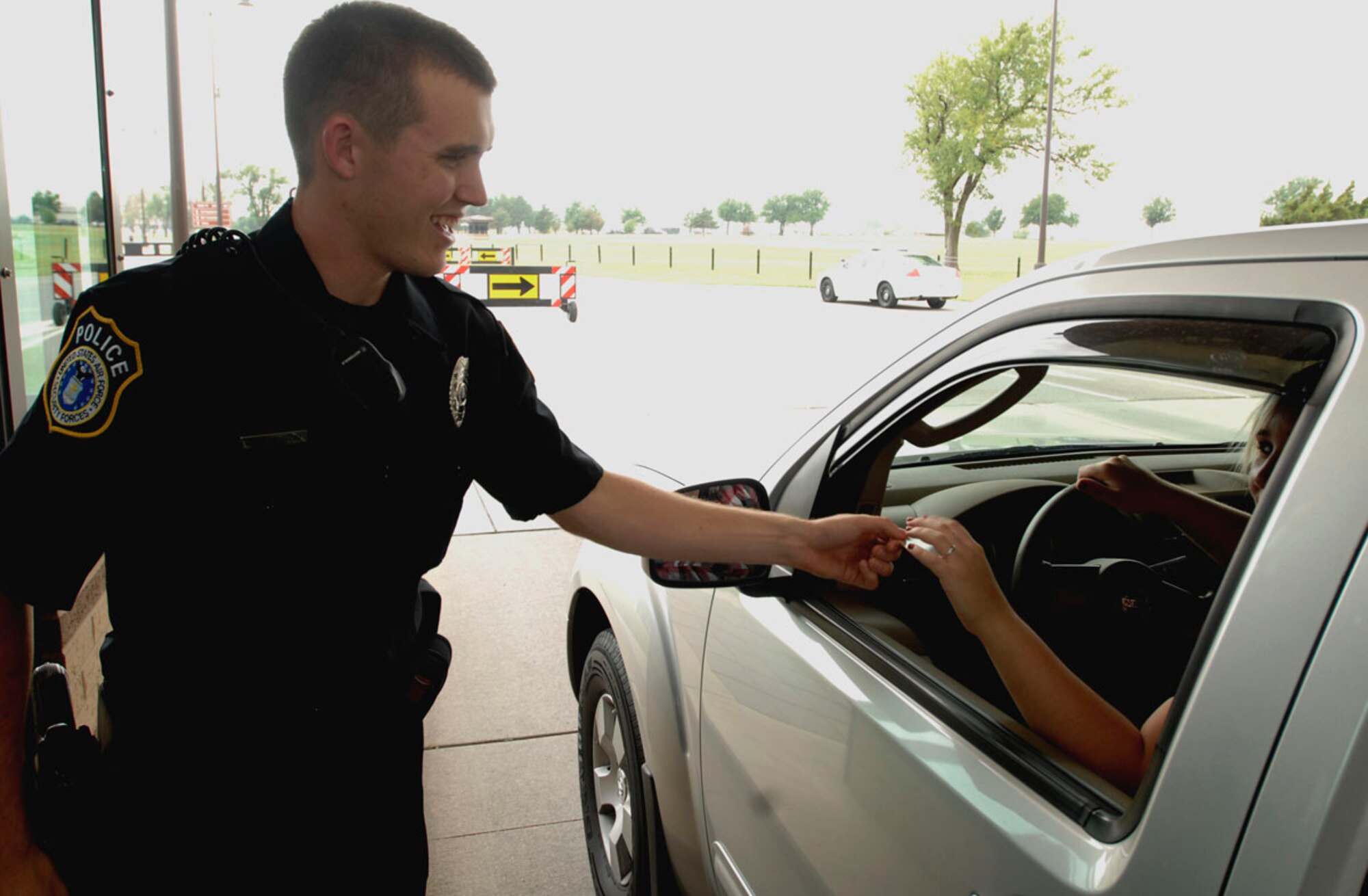 Joshua Johnson, a 22nd Security Forces Squadron civilian police officer, verifies a base visitor’s identification at an entry control point at McConnell Air Force Base, Kan.  Aug. 26.  Mr. Johnson is dressed in the new version of the civilian police uniform, which all civilian patrolmen will wear here beginning Aug. 31. (U.S. Air Force photo/ Senior Airman Jessica Lockoski)