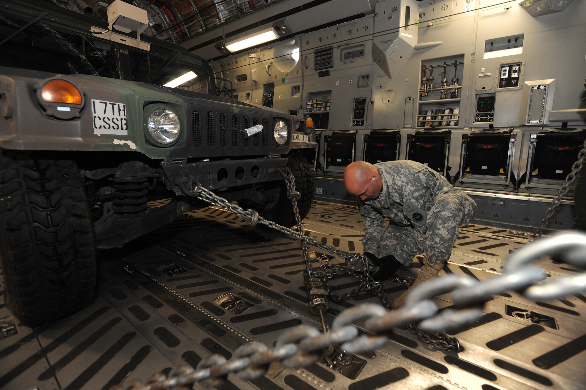 ELMENDORF AIR FORCE BASE, Alaska -- U.S. Army Staff Sgt. Trevor Morden, 17th Combat Service Support Battalion, secures a Humvee to the floor of C-17 Globemaster III prior to take off for Arctic Response August 24. The Army and the Air Force worked together to ensure the success of the exercise. (U.S. Air Force photo/ Staff Sgt. Joshua Garcia) 