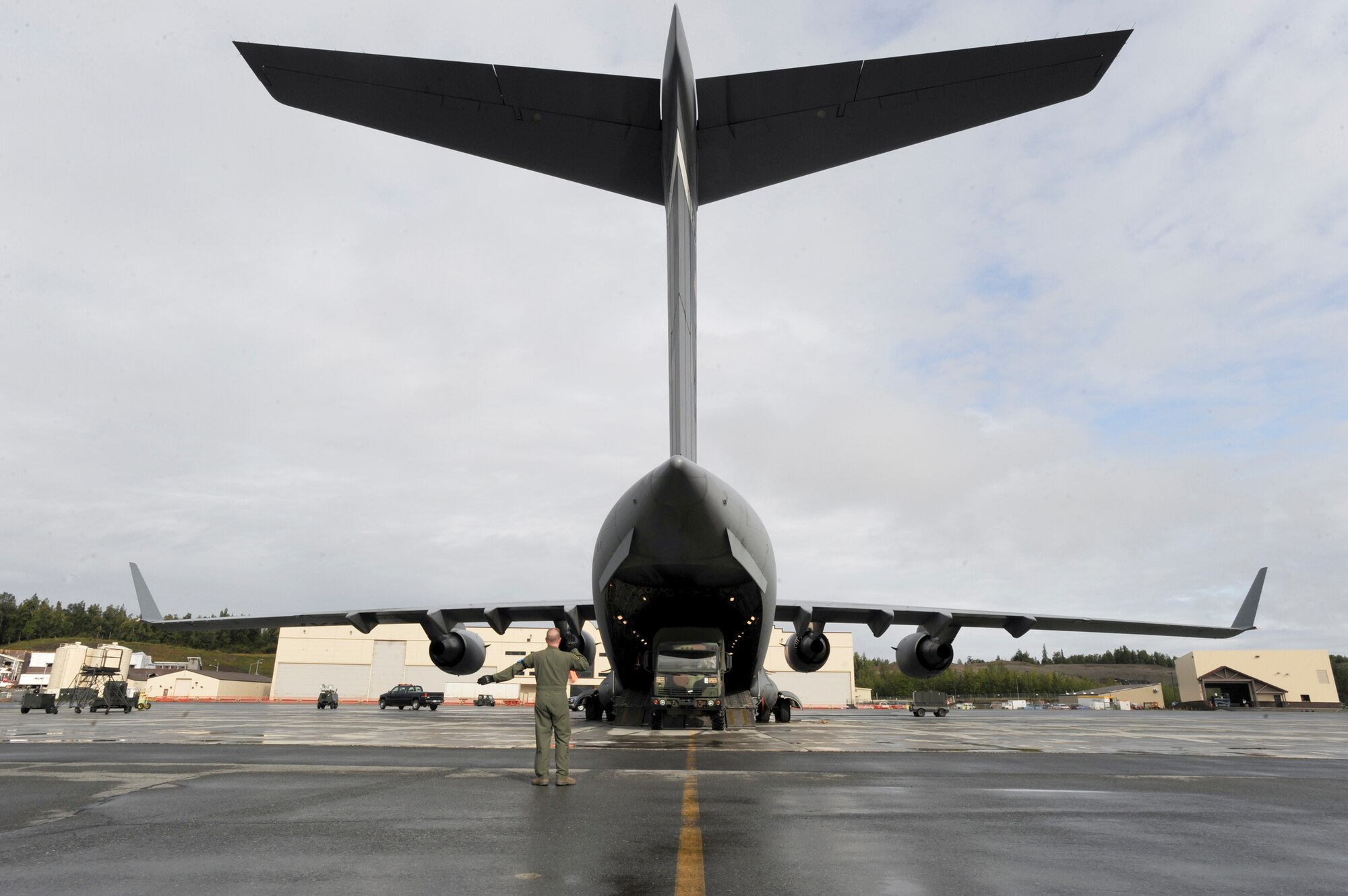 ELMENDORF AIR FORCE BASE, Alaska -- Staff Sgt. Jeremy White, 517th Airlift Squadron loadmaster, guides a U.S. Army vehicle onto a C-17 Globemaster III here, August 24, prior to taking off for Arctic Response. The Air Force and Army worked together for the joint force exercise improving their rapid deploying capabilities. (U.S. Air Force photo/ Staff Sgt. Joshua Garcia)

