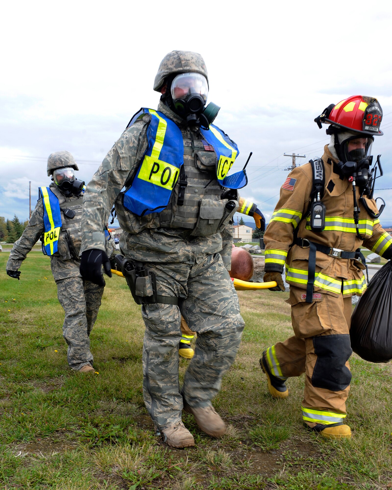 Emergency responders use a litter to carry mock victim to safety during an emergency management exercise Aug. 26, 2009, Eielson Air Force Base, Alaska. These ?victims? pretend to have predetermined injuries and then present themselves to first responders who must put their training into action. The emergency responders are assigned to the 354th Security Forces Squadron and the 354th Civil Engineer Squadron. (U.S. Air Force photo/Airman 1st Class Willard E. Grande II)