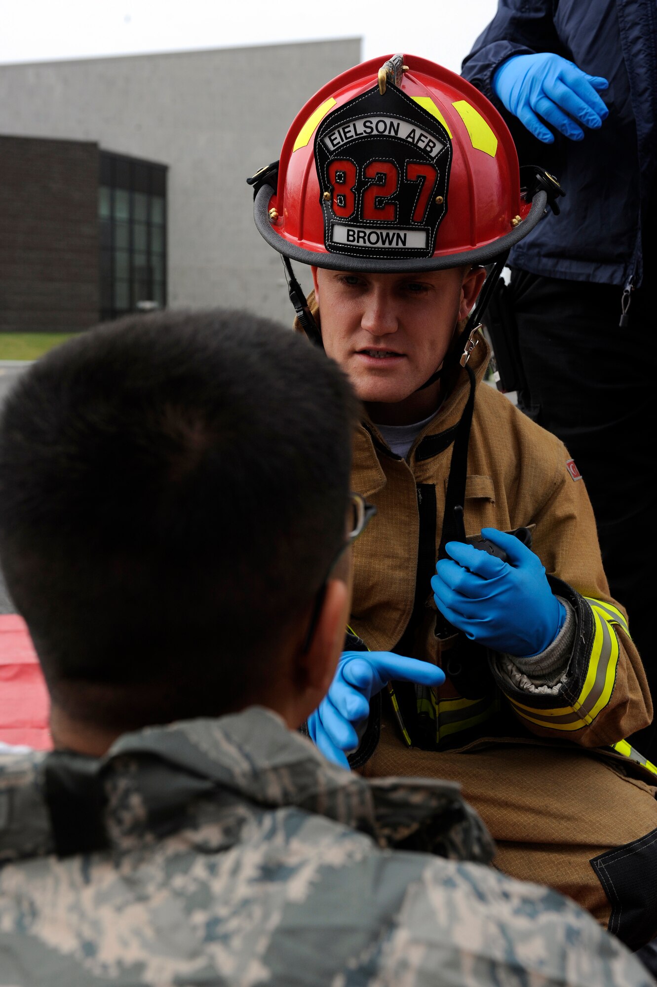 An emergency responder asks a mock victim questions concerning his physical well being Aug. 26, 2009, Eielson Air Force Base, Alaska. A large portion of the exercise was based on how responder?s handled the medical challenges presented to them. The firefighter is assigned to the 354th Civil Engineering Squadron, Fire Protection Flight. (U.S. Air Force photo/Airman 1st Class Willard E. Grande II)