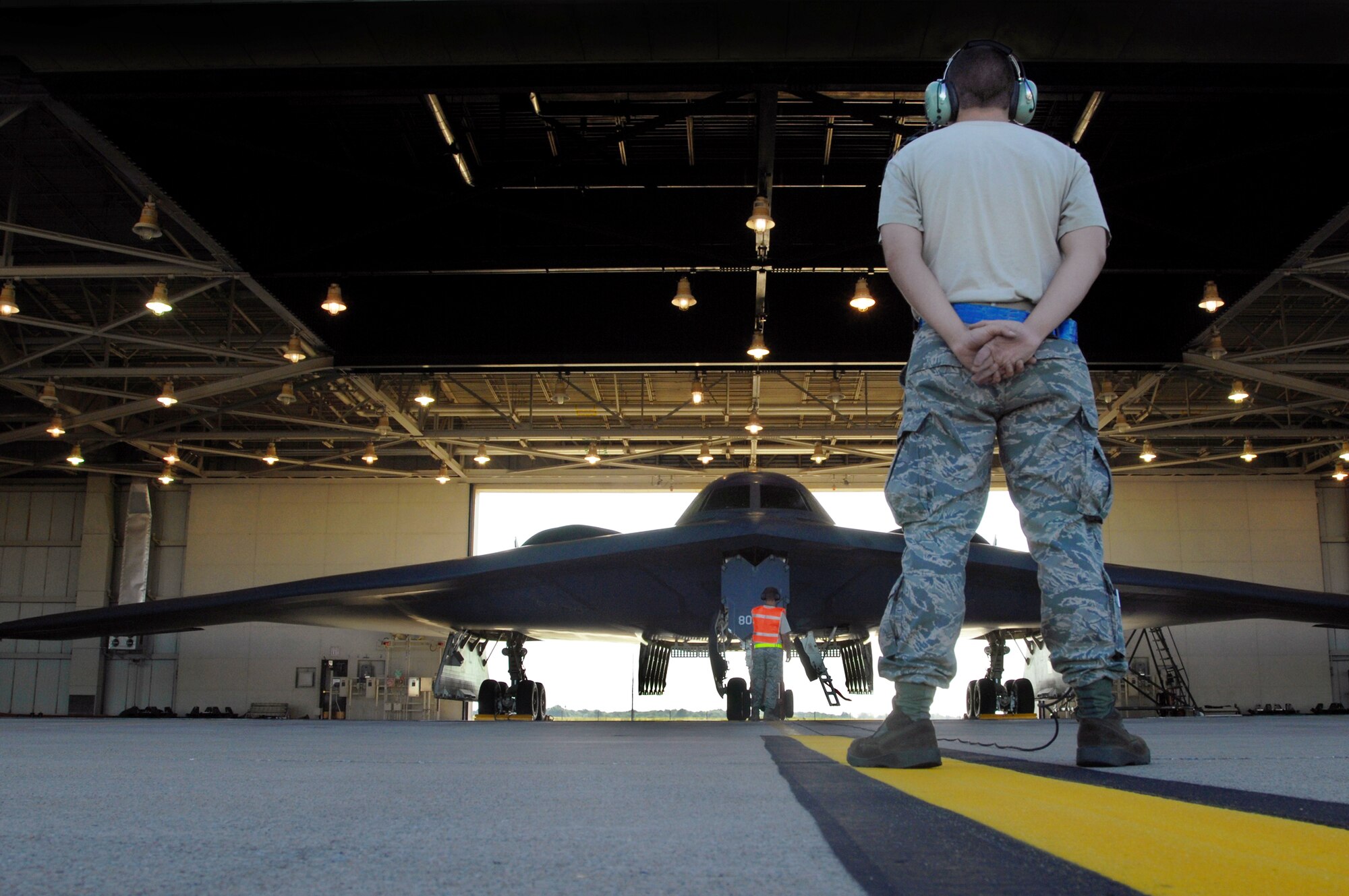 Senior Airman Douglas Anthony stands prepared to marshal a B-2 Spirit out of a hanger for takeoff Aug. 22 at Whiteman Air Force Base, Mo. Twenty B-2s are assigned to the 509th Bomb Wing.  Airman Anthony is a crew chief with the 509th Aircraft Maintenance Squadron. (U.S. Air Force photo/Senior Airman Kenny Holston)