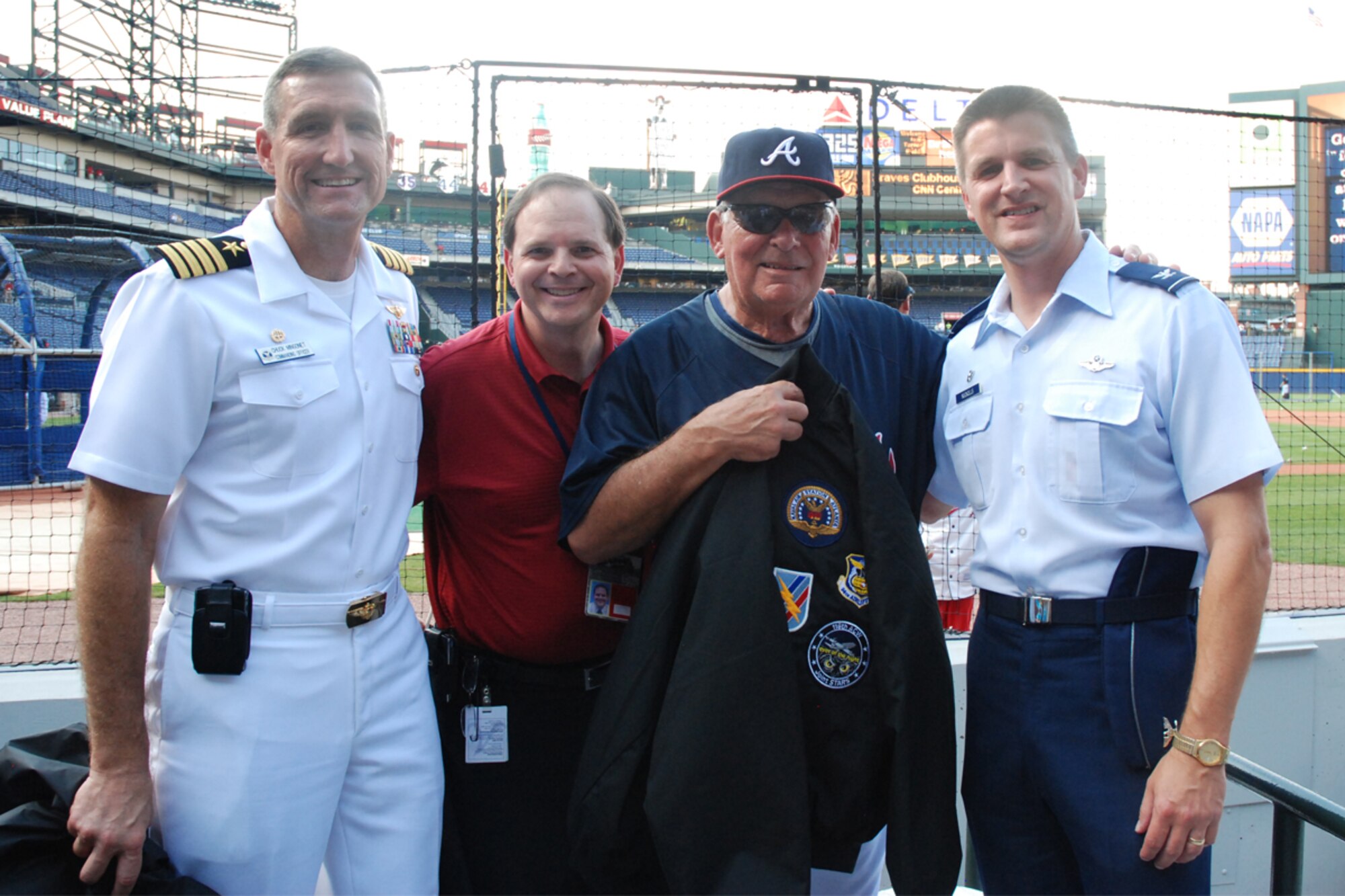 Capt. Chuck Mingonet, commanding officer, Naval Air Station Atlanta and Col. Heath J. Nuckolls, commander, 94th Airlift Wing present  aviation jackets to Paul Adams, sr. director of ticket sales and Bobby Cox, general manager at the Atlanta Braves baseball game Aug. 26. (U.S. Air Force photo/Tech. Sgt. James Branch)