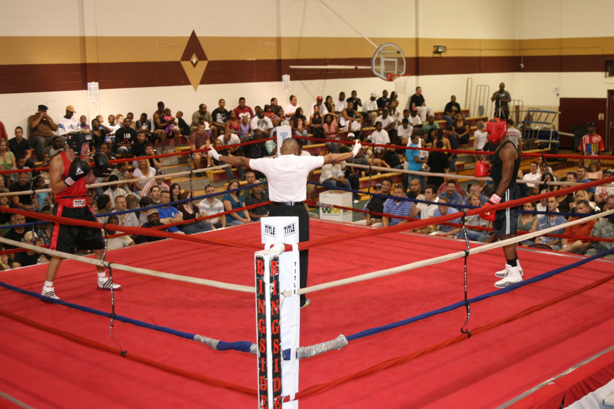 As they wait for the opening bell, Army referee Nate Green keeps boxers Chris Ledbetter, left, and Daniel Logan in their respective corners. Logan, boxing for the Air Force, beat Ledbetter in a three-round decision. (Air Force photo by Becky Pilifant)