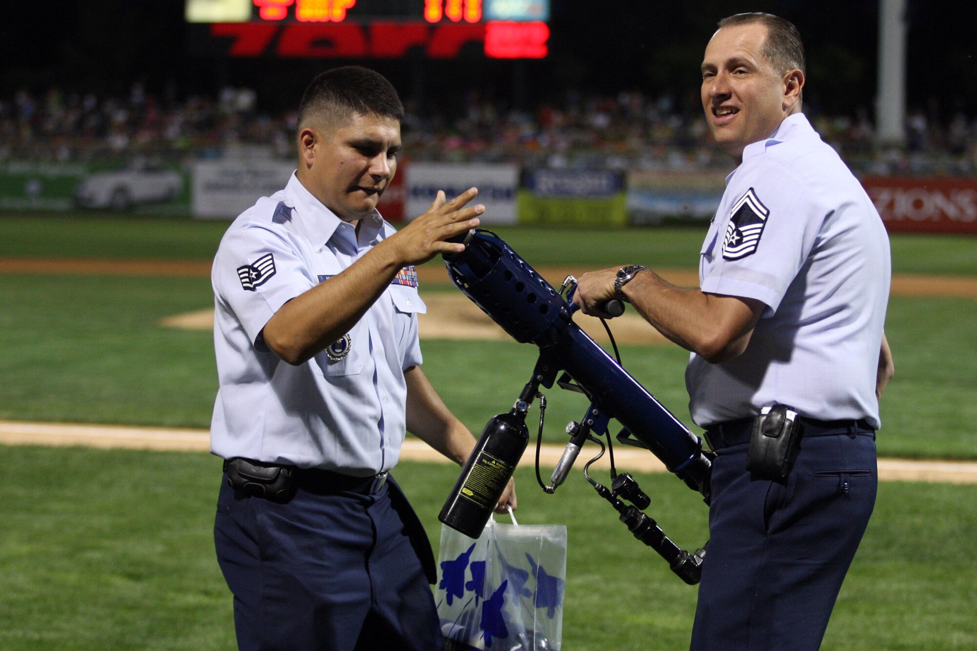 Senior Master Sgt. Bill Bialcak (right) and Staff. Sgt. Jake  Reyes (left), 368th Recruiting Squadron, prepare to launch Air Force T-shirts into the stands at the Salt Lake Bees baseball game Aug. 22, at Spring Mobile Park, Salt Lake City, Utah. The Bees hosted an Air Force Night and had a sold-out crowd of more than 17,000 fans. (Salt Lake Bees photo/Brent Asay)