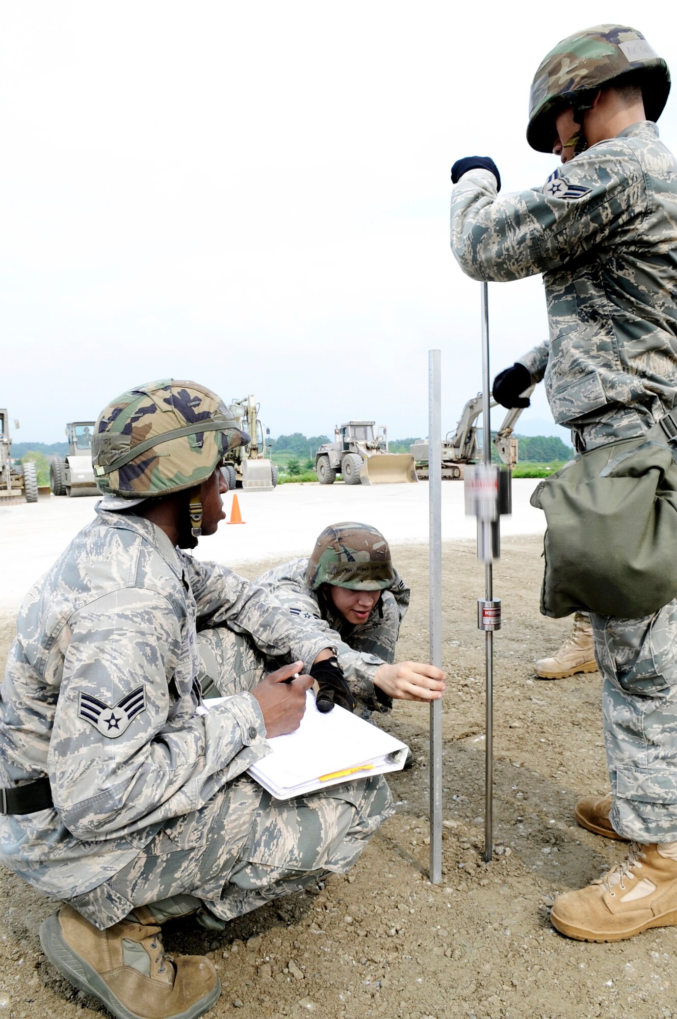 (Left to right) Senior Airman Christopher Davis, Airman 1st Class Jason Alfaro and Airman 1st Class Chi Li test the compaction of a filled crater using a dynamic cone pentrometer Aug. 19 at Jungwon Air Base, Republic of Korea. The reading is used to determine if the crater is sufficiently filled and compacted to withstand aircraft landings. This process was part of a joint combined rapid runway repair training exercise with Airmen from the South Korean air force's 19th Tactical Fighter Wing and 91st Air Civil Engineer Group. Airmen Davis, Alfaro and Chi Li are assigned to the 51st Civil Engineer Squadron at Osan Air Base, South Korea. (U.S. Air Force photo/Senior Airman Stephenie Wade)