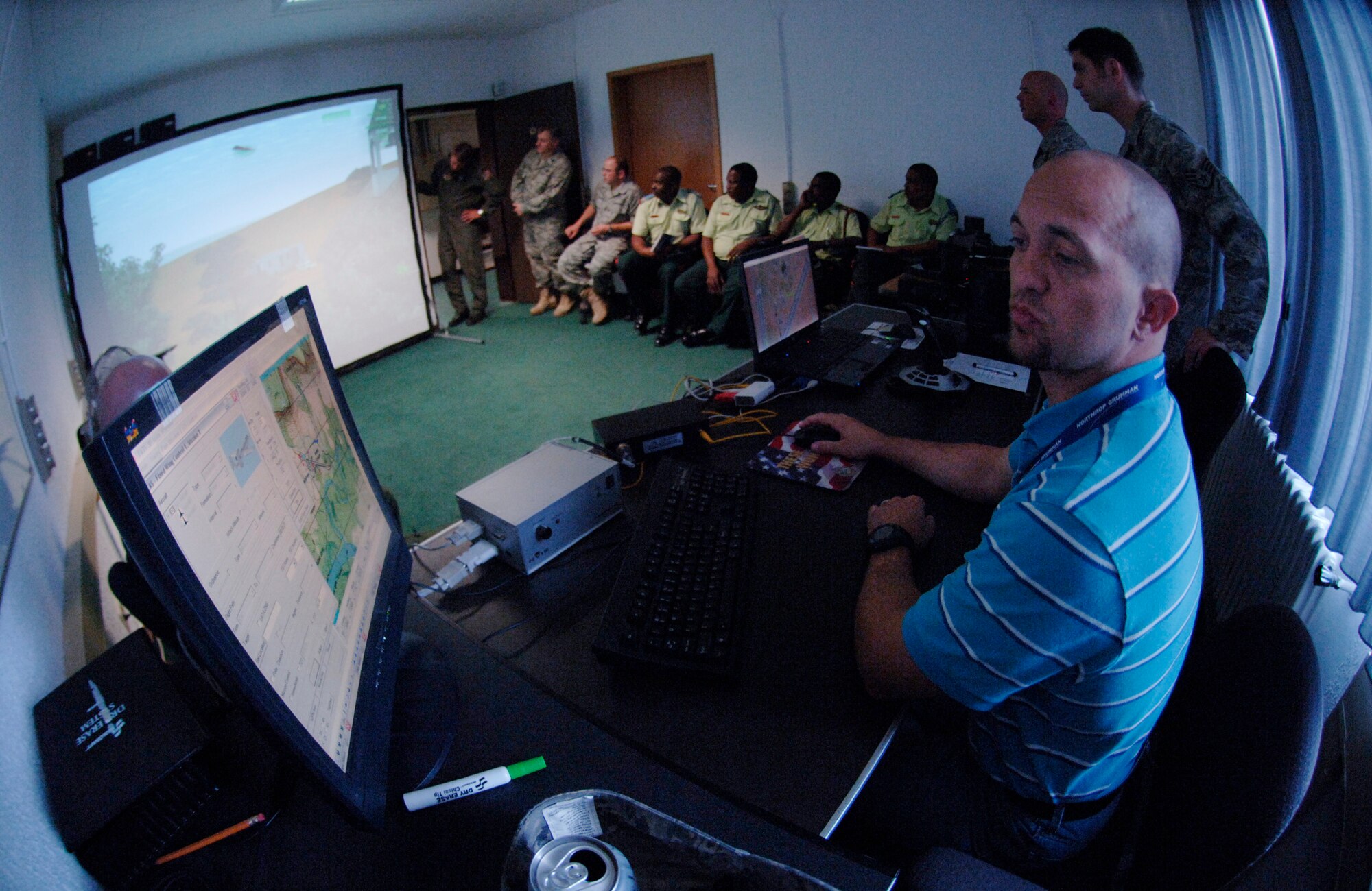 Mr. Casey Ficus, simulator operator, works the close air support simulator
for Lt. Col. Tony Forkner, the commander of the U.S.Air Forces Europe Air-Ground Operations School, and guests from Botswana.  They are the first African military delegation to visit the facility.. (U.S. Air Force Photo by Master Sgt. Donald Wagers.)
