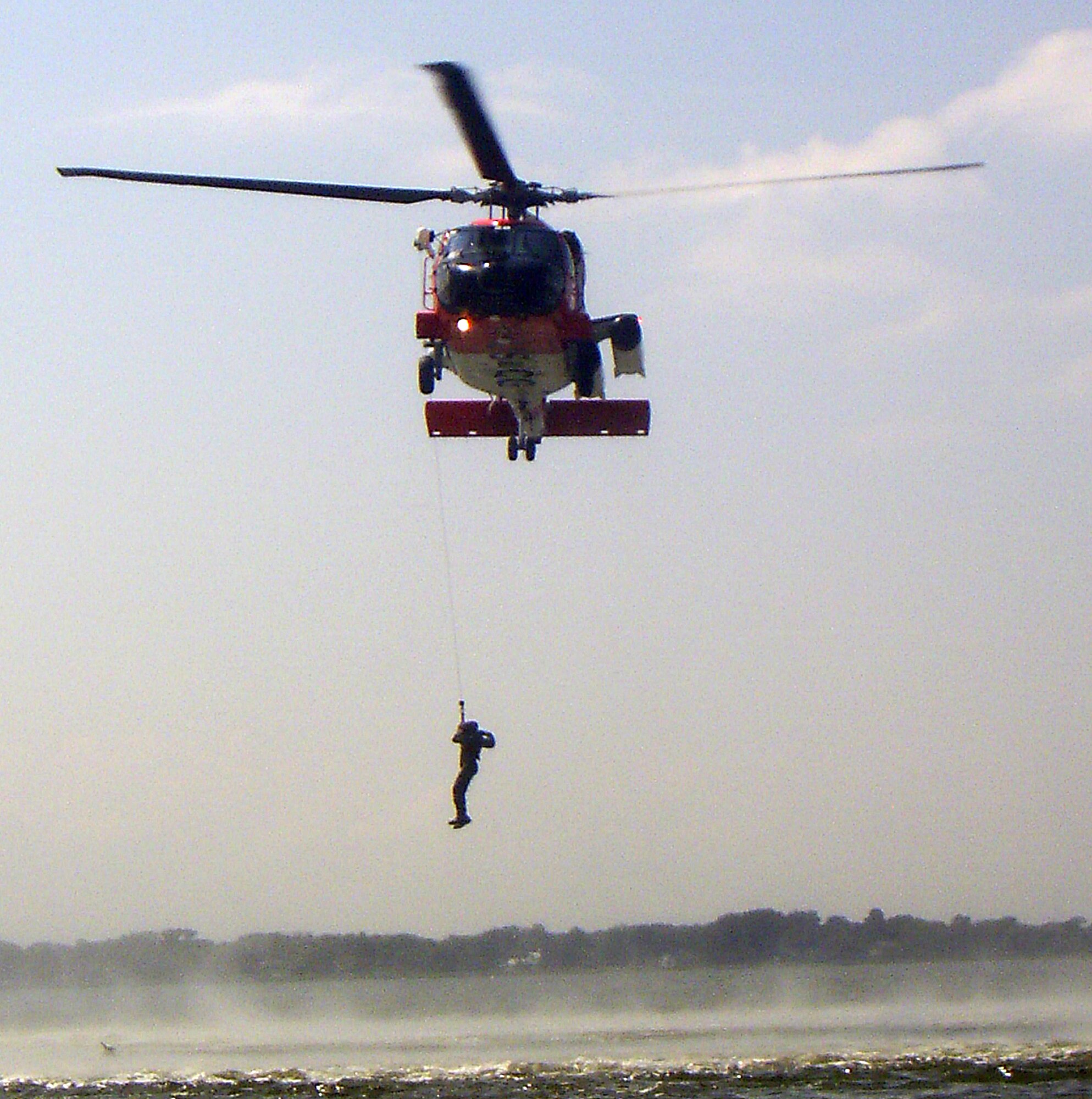 LANGLEY AIR FORCE BASE, Va. --  A MH-60J "Jayhawk" rescue helicopter hoists a Survival, Evasion, Resistance and Escape student from the water during survival training here Aug. 25.  The survival training, conducted by SERE specialists, teaches students how to survive if they egress over water. The course also covers proper signaling, desalinating water, finding sustenance and how to properly release from a parachute drag. Pilots are required to complete water survival training every three years. (U.S. Air Force photo/Senior Airman Zachary Wolf)