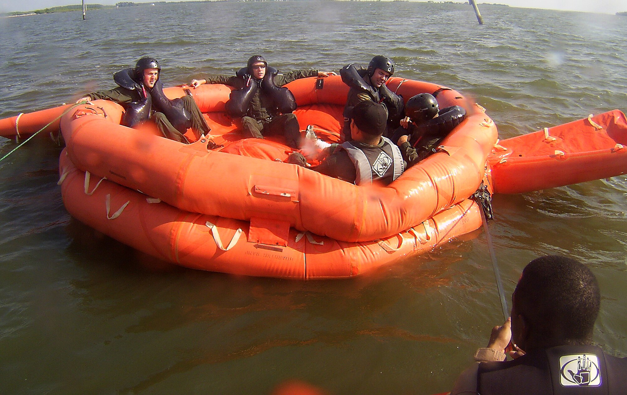 LANGLEY AIR FORCE BASE, Va. -- Survival, Evasion, Resistance and Escape students prepare to perform a 20-man egress during water survival training here Aug. 25.  The training, conducted by SERE specialists, teaches students how to endure life in a raft, as well as how to best utilize a survival kit. The course covers proper signaling, desalinating water, finding sustenance and how to properly release from a parachute drag. Pilots are required to complete water survival training every three years. (U.S. Air Force photo/Senior Airman Zachary Wolf)