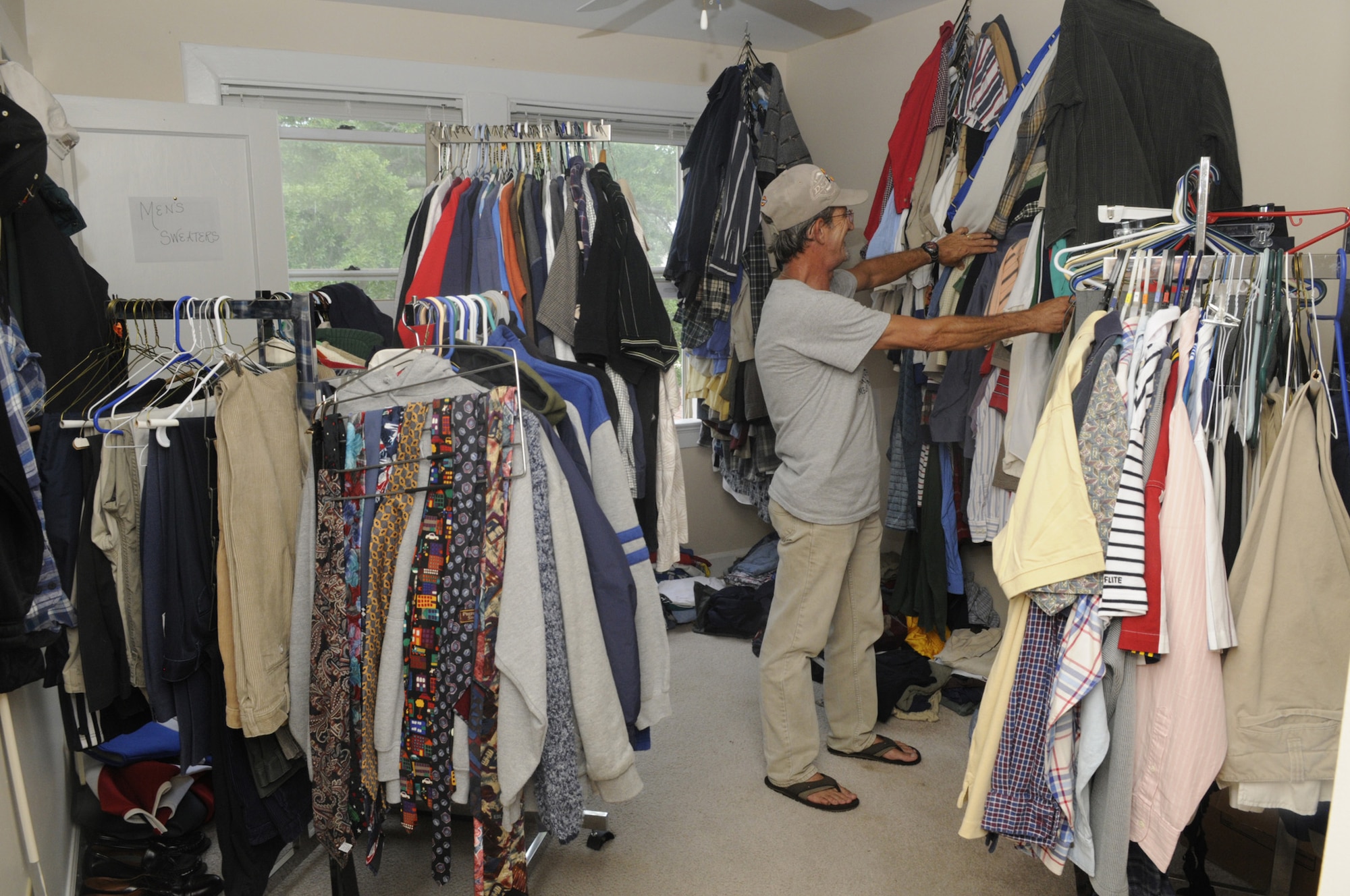 John Green, Airman's Attic volunteer, looks through the men's clothing available at the attic. U. S. Air Force photo by Sue Sapp