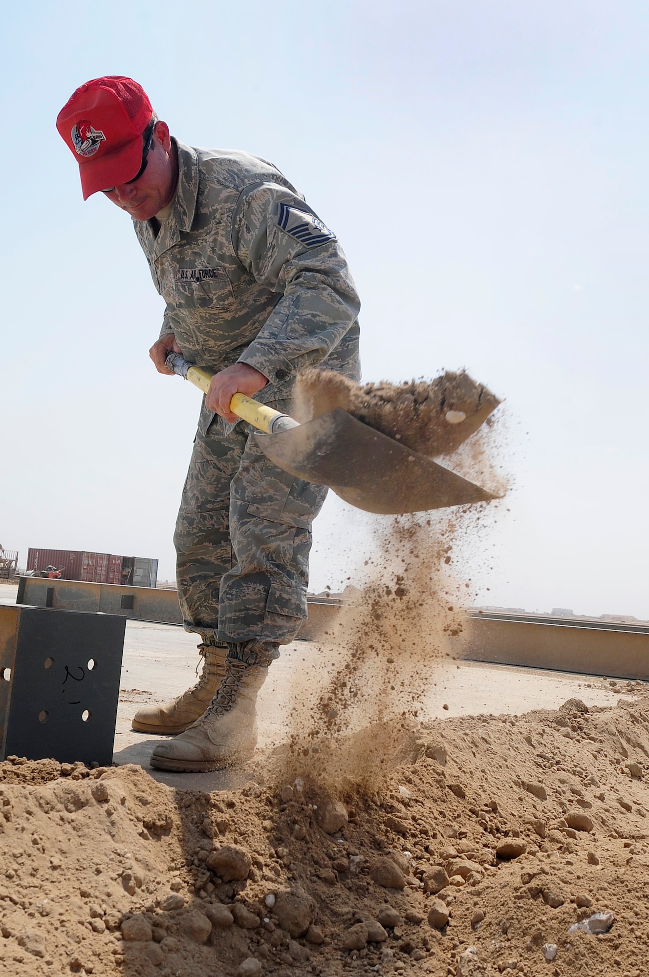 ALI BASE, Iraq - U.S. Air Force Senior Master Sgt. Jeff Malherek, site superintendent, 557th Expeditionary Red Horse Squadron, clears sand from the foundation of new AAFES facility project here, Aug. 26, 2009. Sergeant Malherek is originally from Riverton, Minn. and is deployed here from Aviano Air Base, Italy. (U.S. Air Force photo/ Airman 1st Class Tony R. Ritter) (Released)