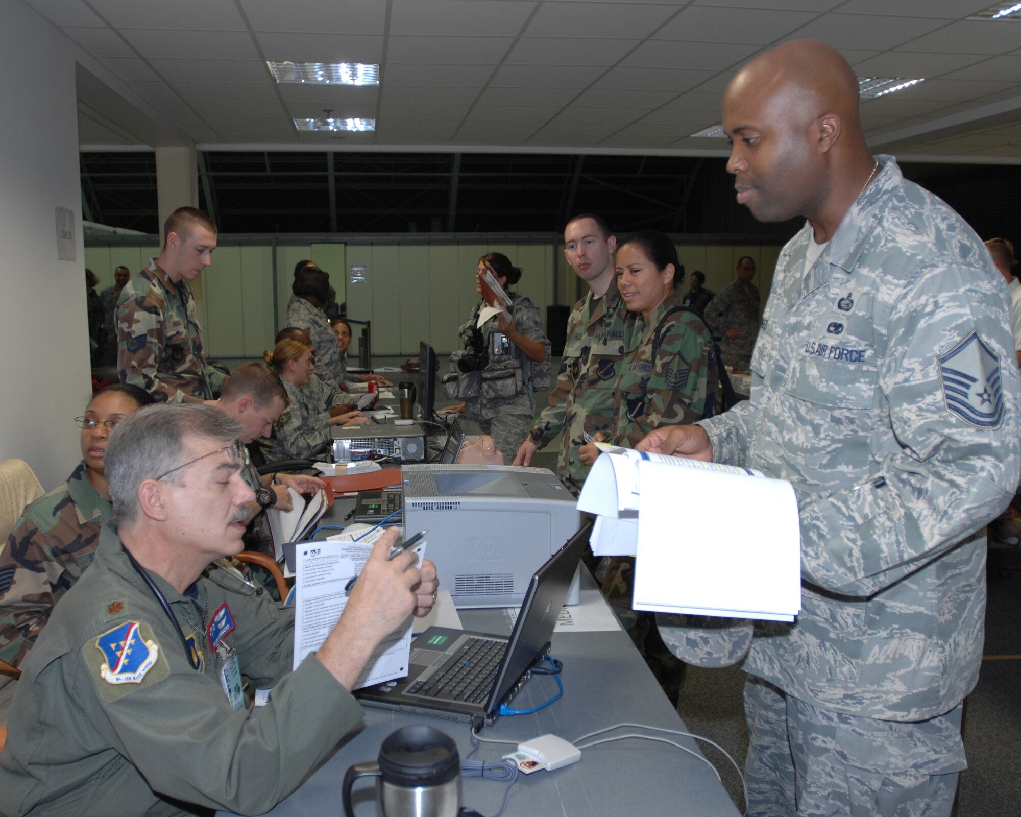 Maj. Mark Summers, 39th Medical Support Squadron, reviews the medical questionnaire of Master Sgt.  Larry Jones, 39th  Air Base Wing, during a deployment exercise, Wednesday, Aug. 26, 2009, Incirlik Air Base, Turkey.  Participants from each  squadron  packed a duffel bag of uniforms and personal hygiene items before processing to deploy to a fictitious location. (U.S. Air Force photo/Staff Sgt. Lauren Padden)